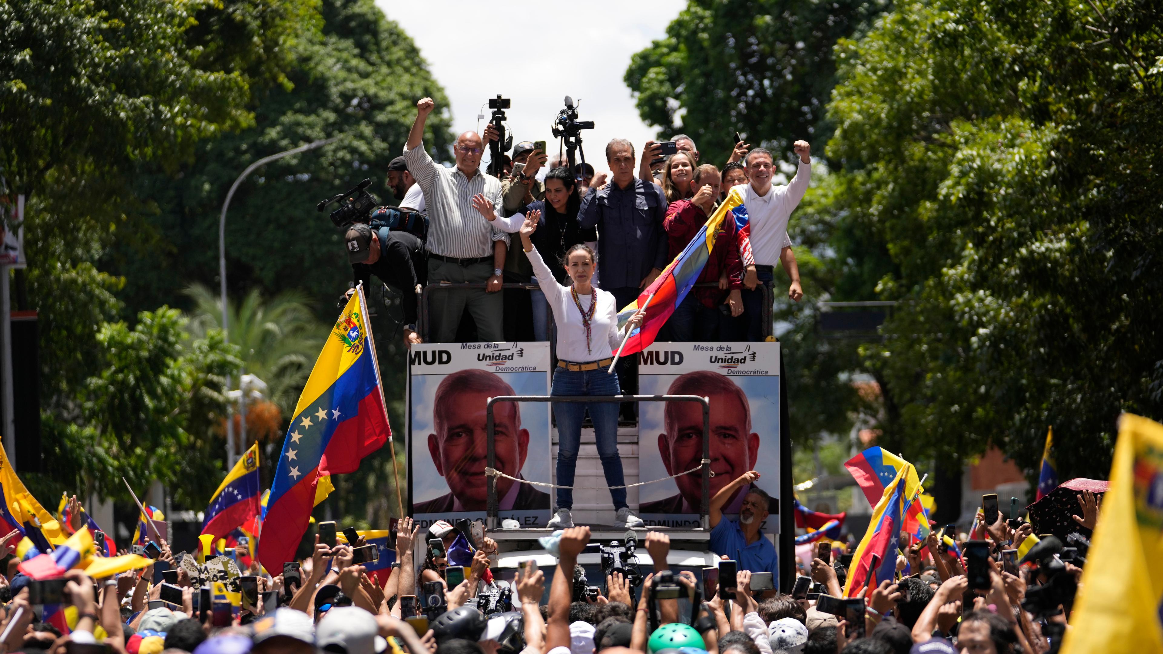 03.08.2024: Die Oppositionsführerin Maria Corina Machado hält eine Nationalflagge und winkt ihren Anhängern zu, als sie zu einer Kundgebung in Caracas eintrifft.