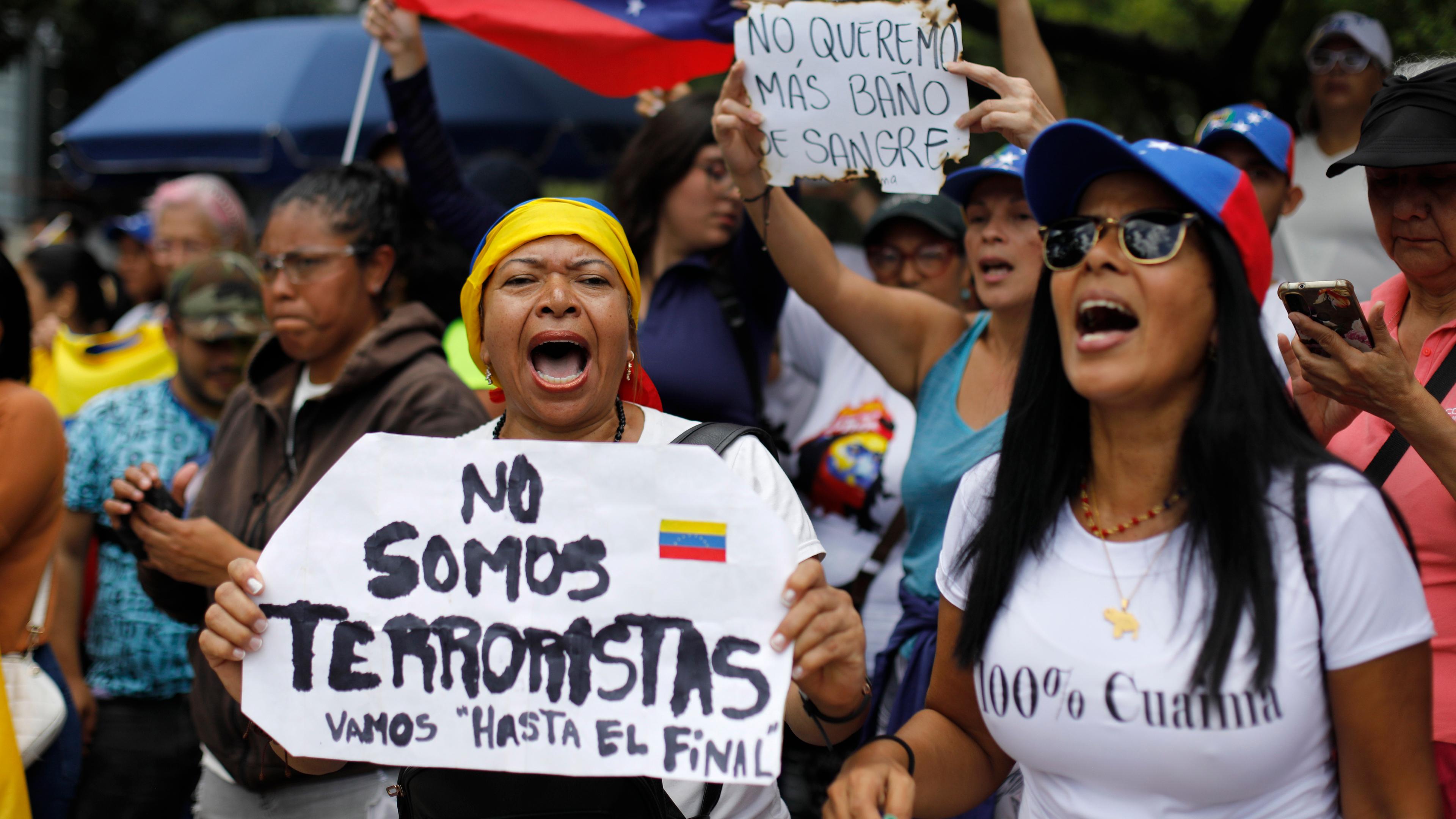 Caracas: Eine Frau hält ein Schild mit der spanischen Aufschrift «Wir sind keine Terroristen», während sie mit anderen Anhängern auf die Ankunft der Oppositionsführerin Maria Corina Machado wartet.