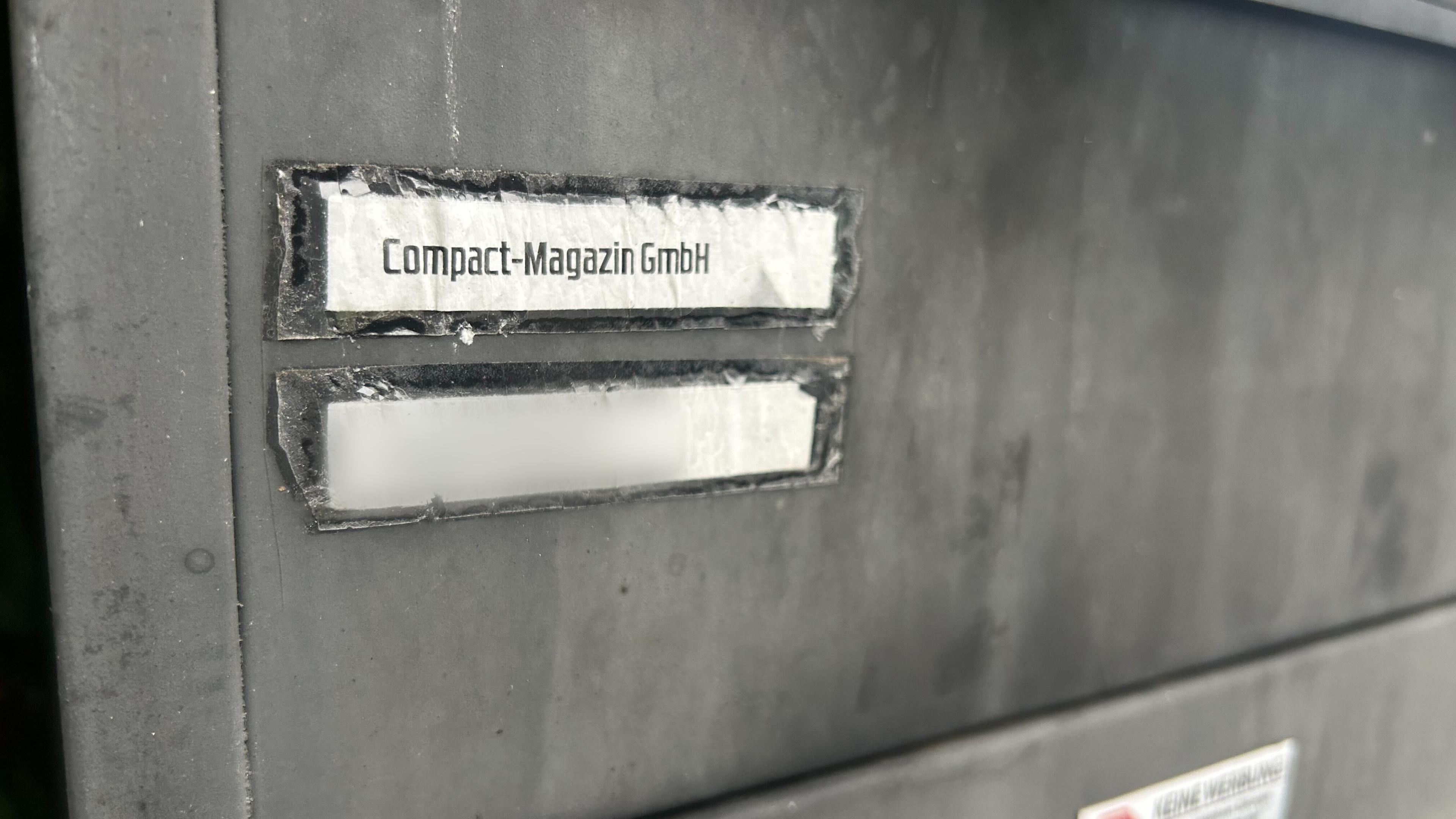 Die Aufschrift "Compact-Magazin GmbH" steht an einem Briefkasten.
