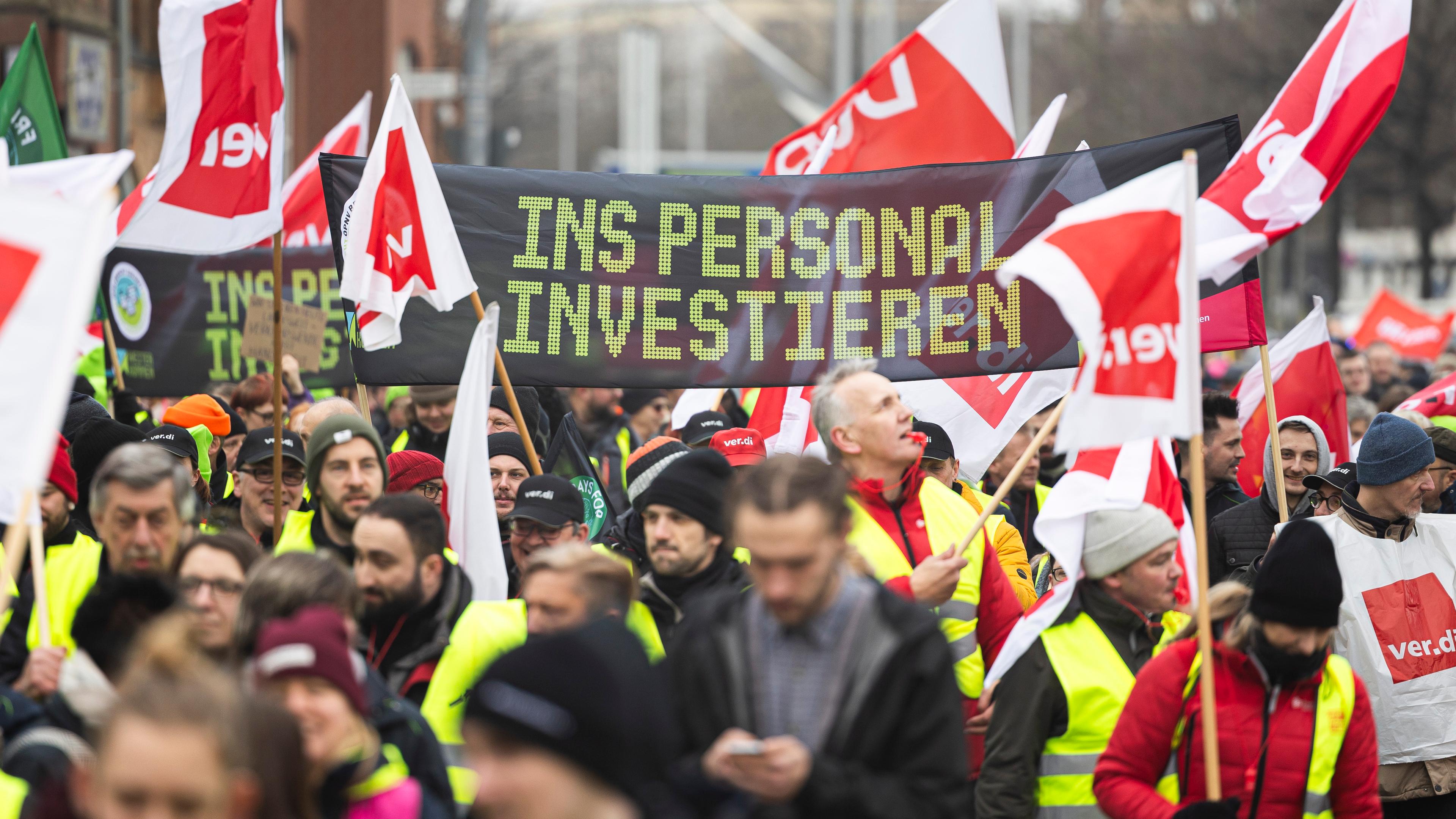 Niedersachsen, Hannover: Teilnehmer einer Verdi-Demonstration laufen mit einem Banner mit der Aufschrift «Ins Personal investieren» durch die Innenstadt von Hannover. 