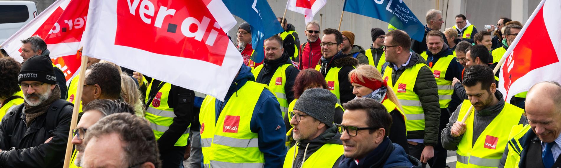 Hessen, Frankfurt/Main: Ein Protestzug von Streikenden zieht mit Bannern und Verdi-Fahnen vom Lufthansa Aviation Center zum Terminal 1.