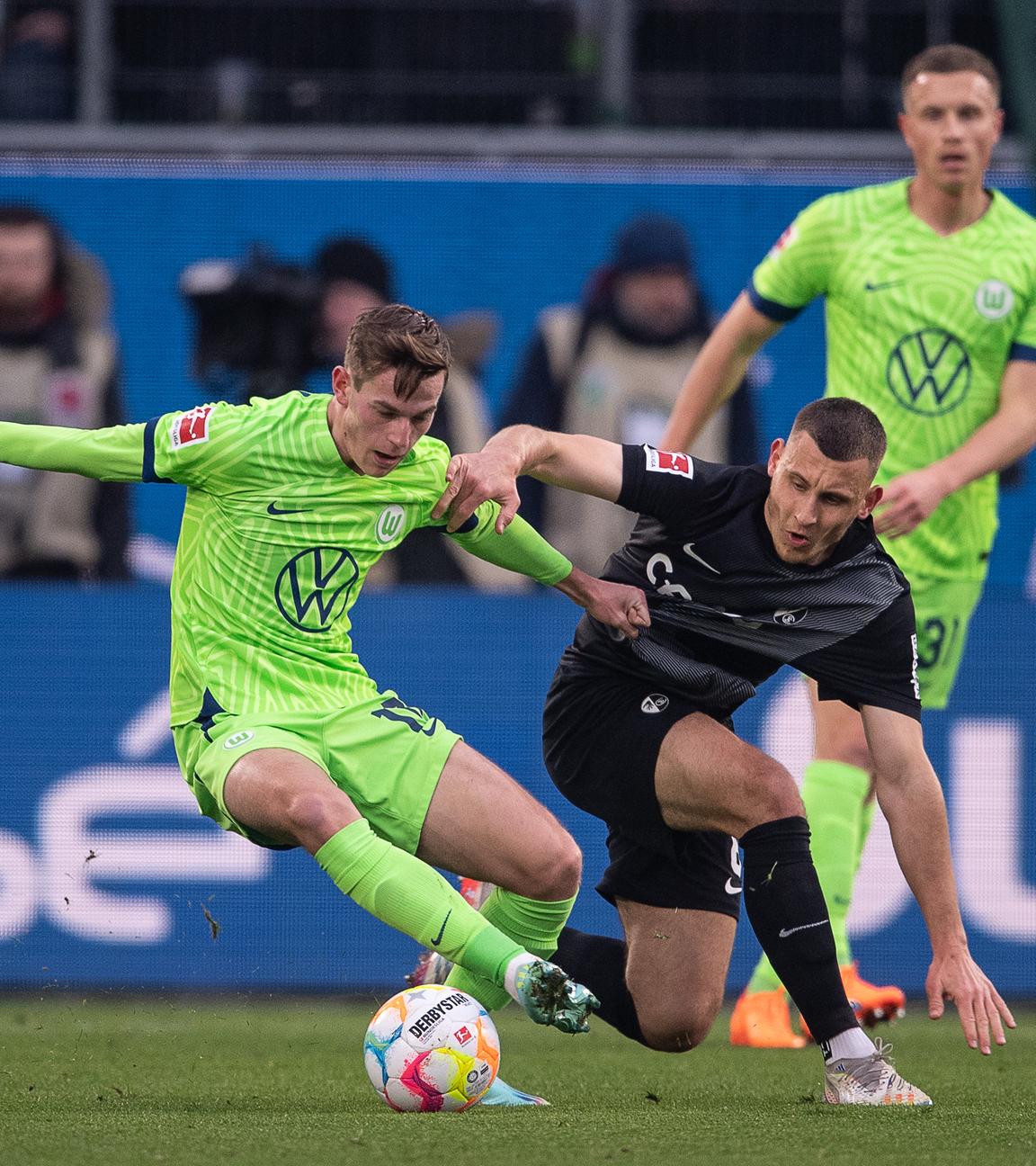 21.01.2023, Niedersachsen, Wolfsburg: Fußball: Bundesliga, VfL Wolfsburg - SC Freiburg, 16. Spieltag, Volkswagen Arena. Wolfsburgs Jakub Kaminski (l) spielt gegen Freiburgs Maximilian Eggestein.