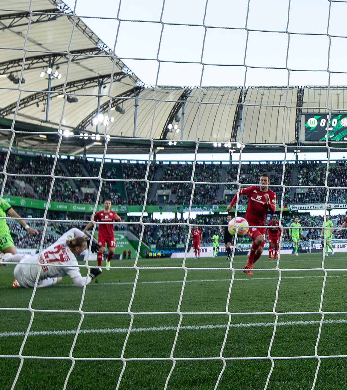 30.04.2023, Niedersachsen, Wolfsburg: Fußball: Bundesliga, VfL Wolfsburg - FSV Mainz 05, 30. Spieltag, Volkswagen Arena. Wolfsburgs Jonas Wind (l) erzielt gegen Mainz Torwart Robin Zentner das Führungstor zum 1:0. 