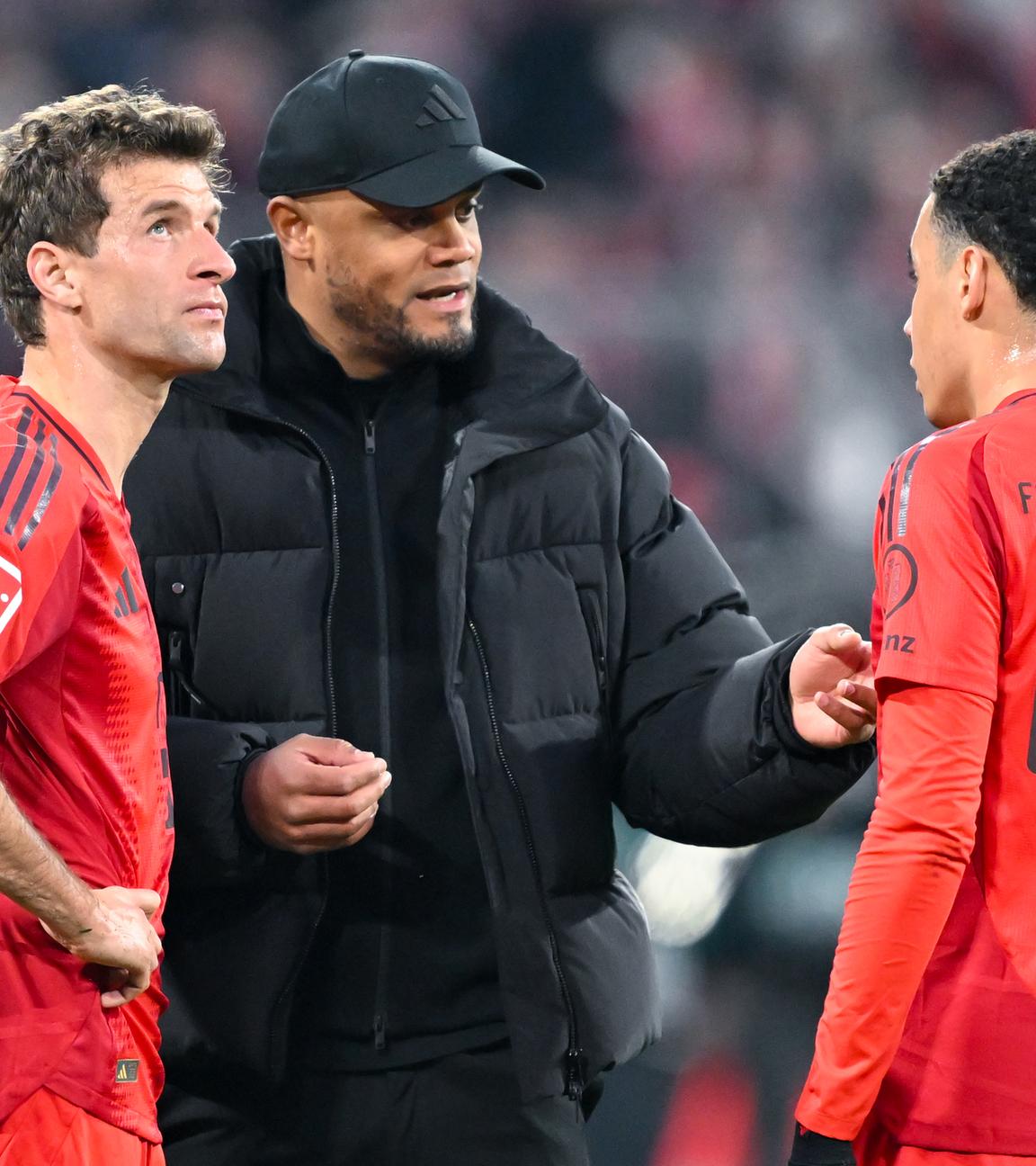 Bayern Münchens Trainer Vincent Kompany spricht mit Thomas Müller (l) und Jamal Musiala.