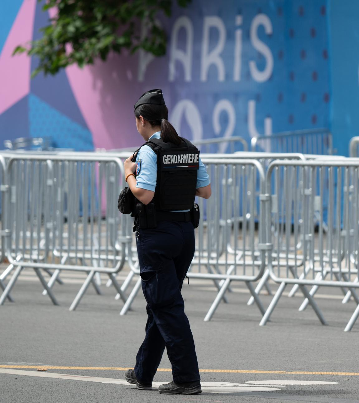 Eine Mitarbeiterin der Gendarmerie steht am Grand Palais in Paris vor zahlreichen Absperrgittern.