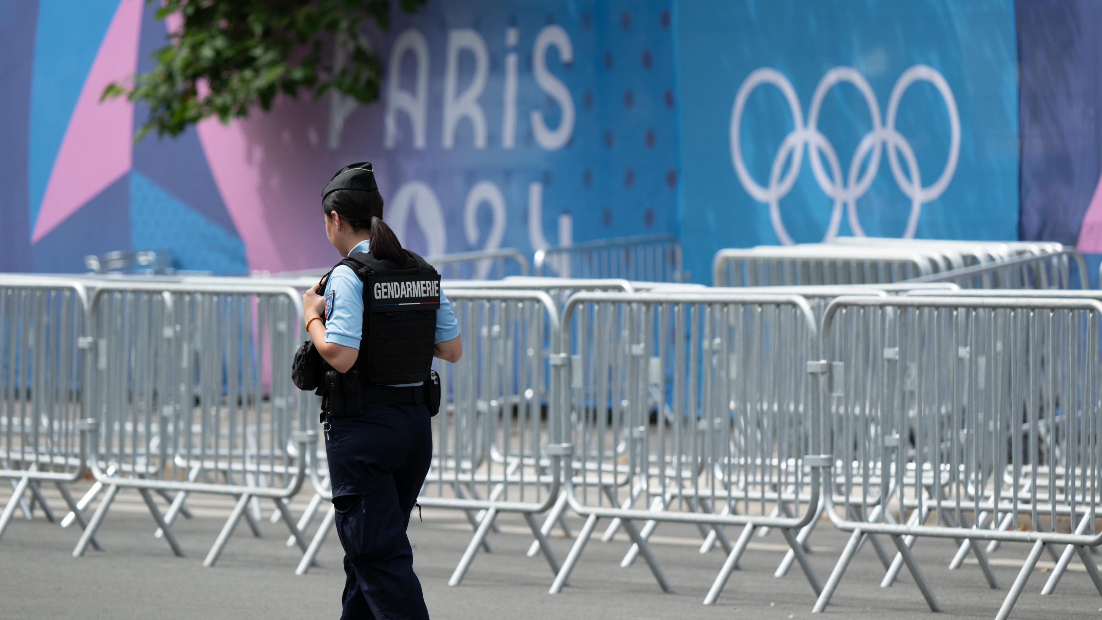 Eine Mitarbeiterin der Gendarmerie steht am Grand Palais in Paris vor zahlreichen Absperrgittern.