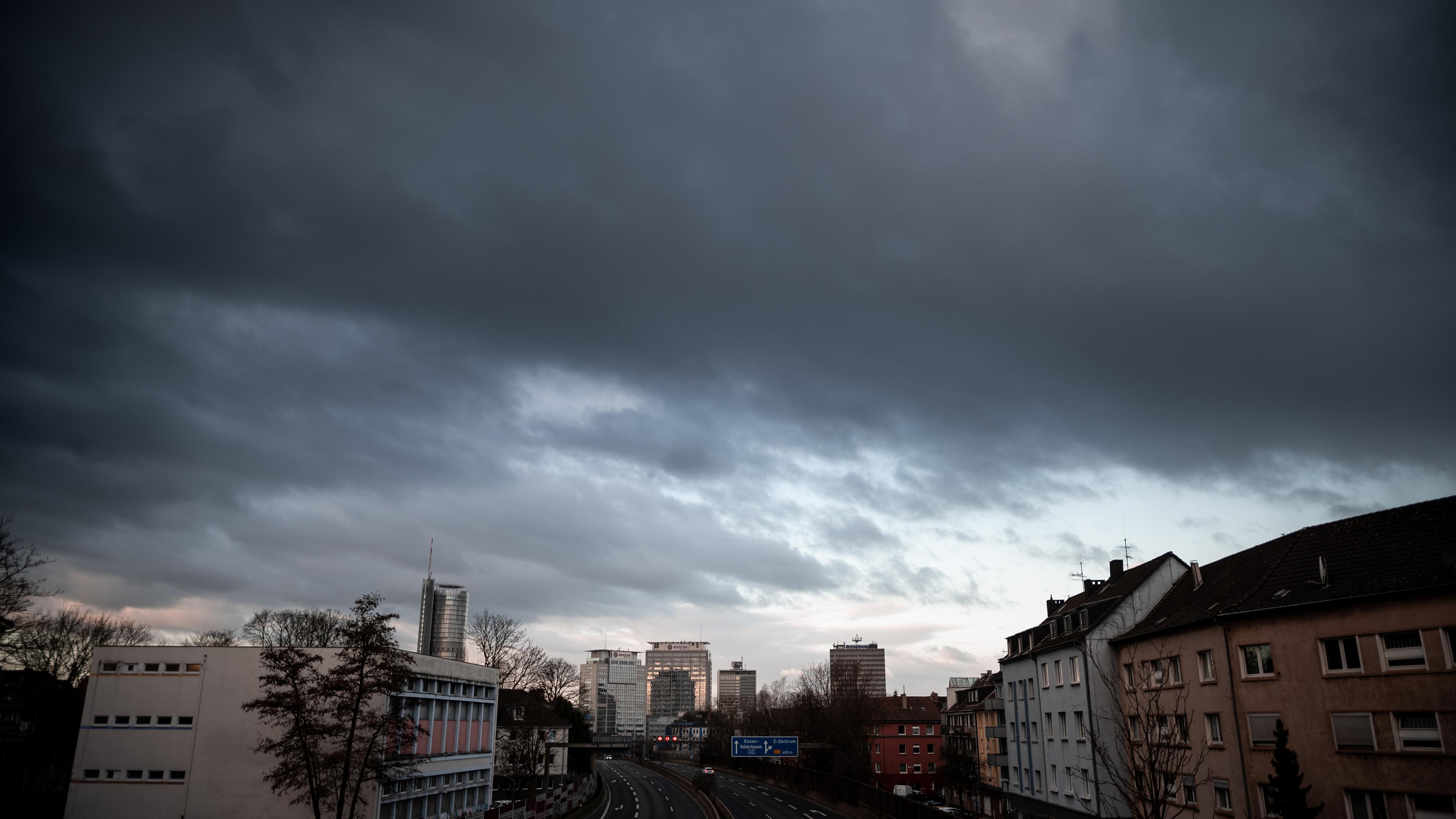 Essen: Dunkle Wolken ziehen hinter der Innenstadt von Essen mit Blick auf die Autobahn A40 her. Gerade erst ist ein schwerer Sturm vorbei, da ist schon der nächste über Deutschland.