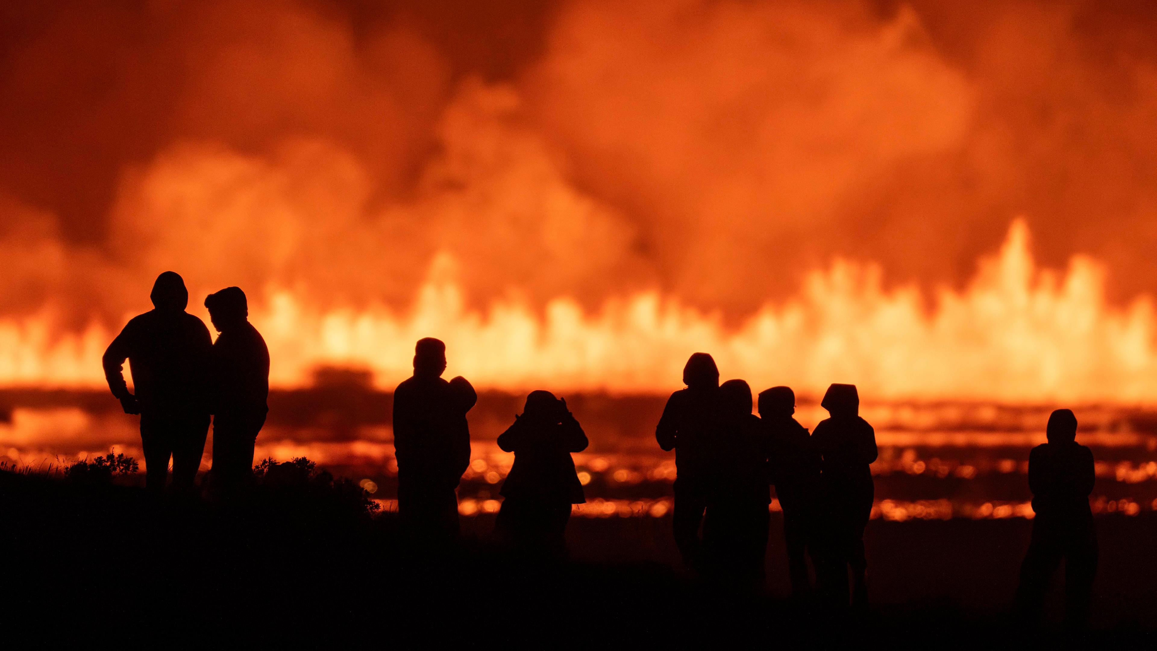 Touristen und Besucher versuchen, den Ausbruch aus der Ferne von der Kreuzung zwischen Reykjanesbraut, Island, und der Straße nach Grindavik zu sehen, am 22. 08. 2024. 