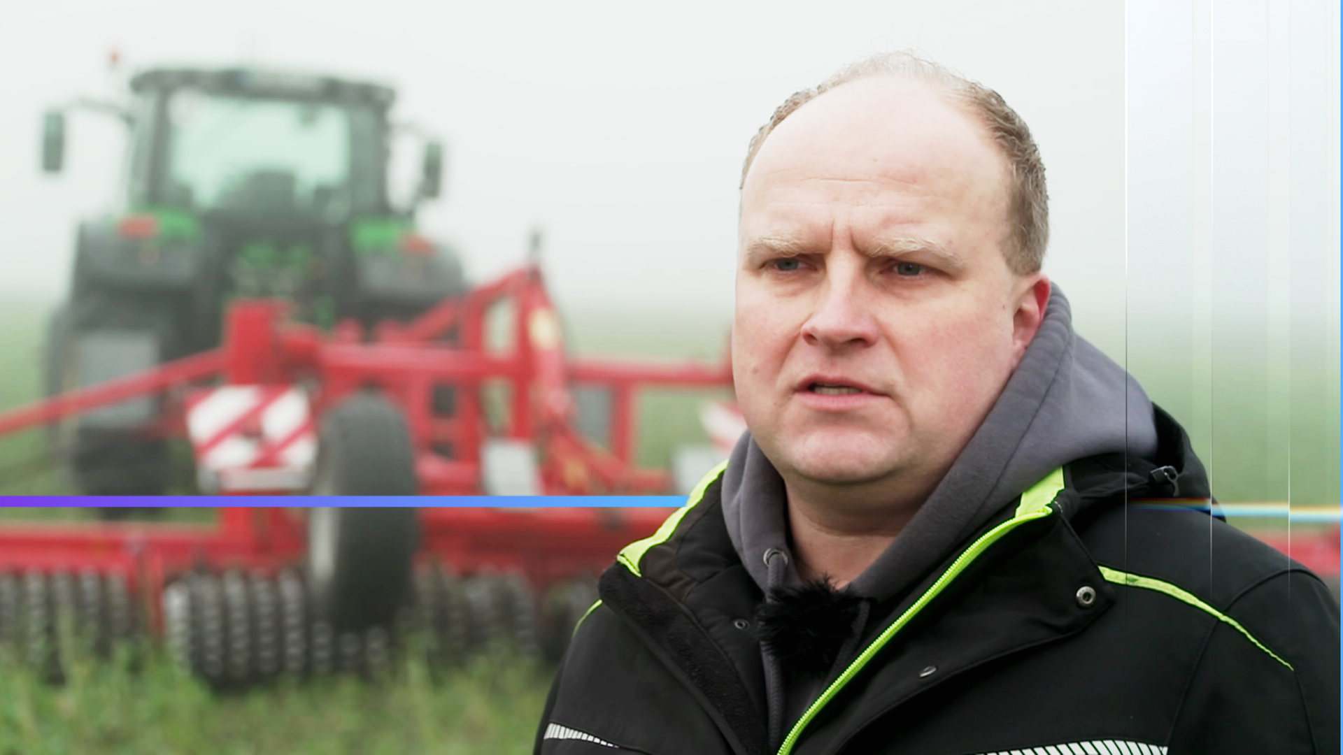 Mann schaut mit skeptischem Blick an der Kamera vorbei. Im Hintergrund Nebel und ein landwirtschaftliches Gerät auf einem Feld.