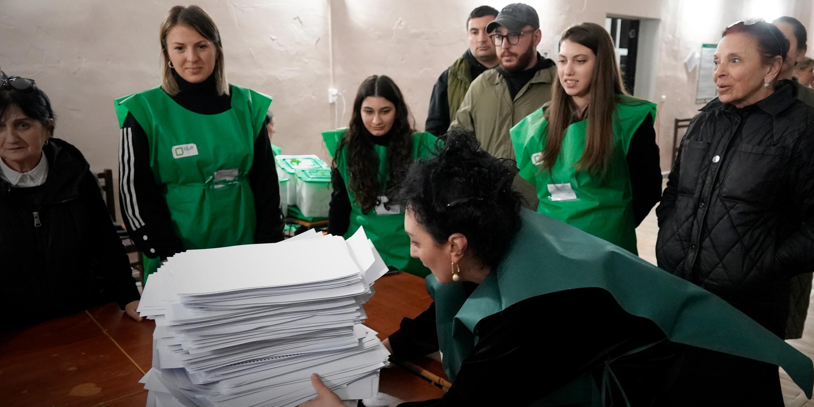 Mitglieder einer Wahlkommission bereiten sich auf die Auszählung der Stimmzettel in einem Wahllokal nach der Parlamentswahl in Tiflis (Georgien), aufgenommen am 26.10.2024 