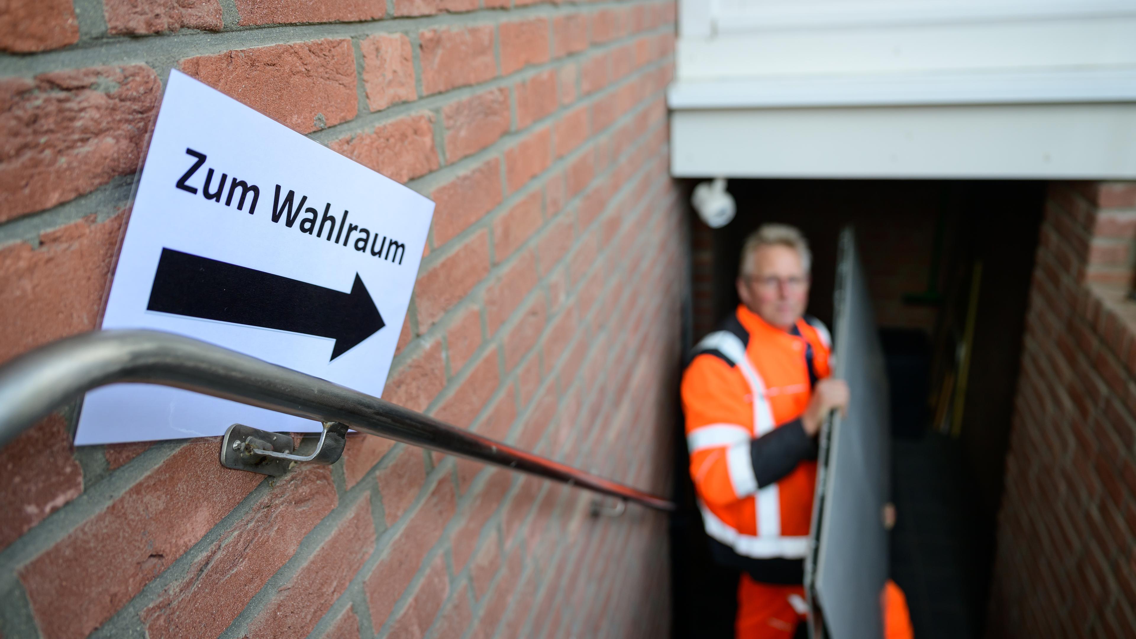 Schild mit einem Pfeil in die Richtung, in der der Wahlraum liegt