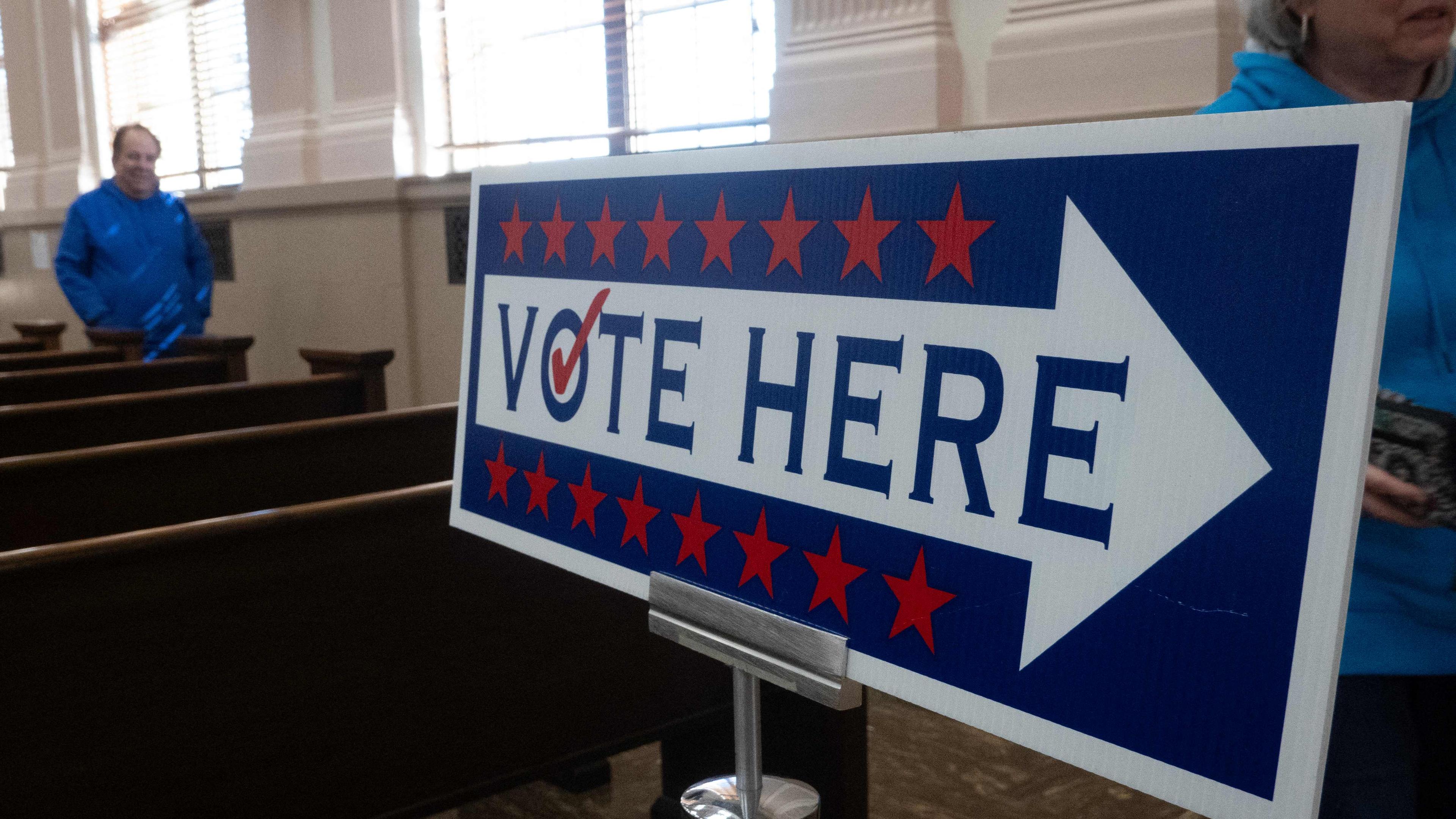 Schild mit einem Pfeil, wo man für die US-Wahl 2024 abstimmen kann, in der City Hall in Racine in Wisconsin.