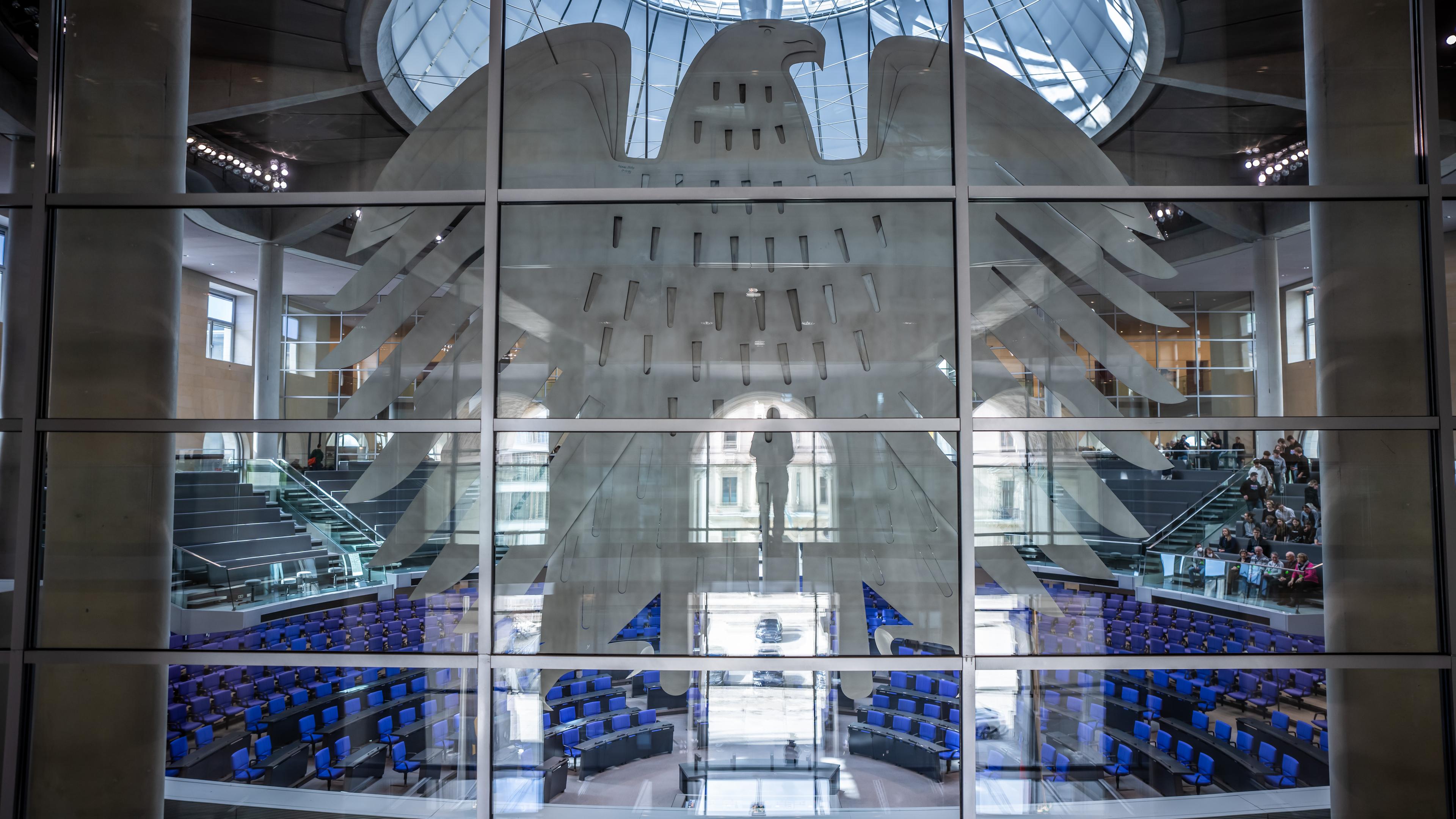 Der Plenarsaal des deutschen Bundestages durch eine Glasscheibe