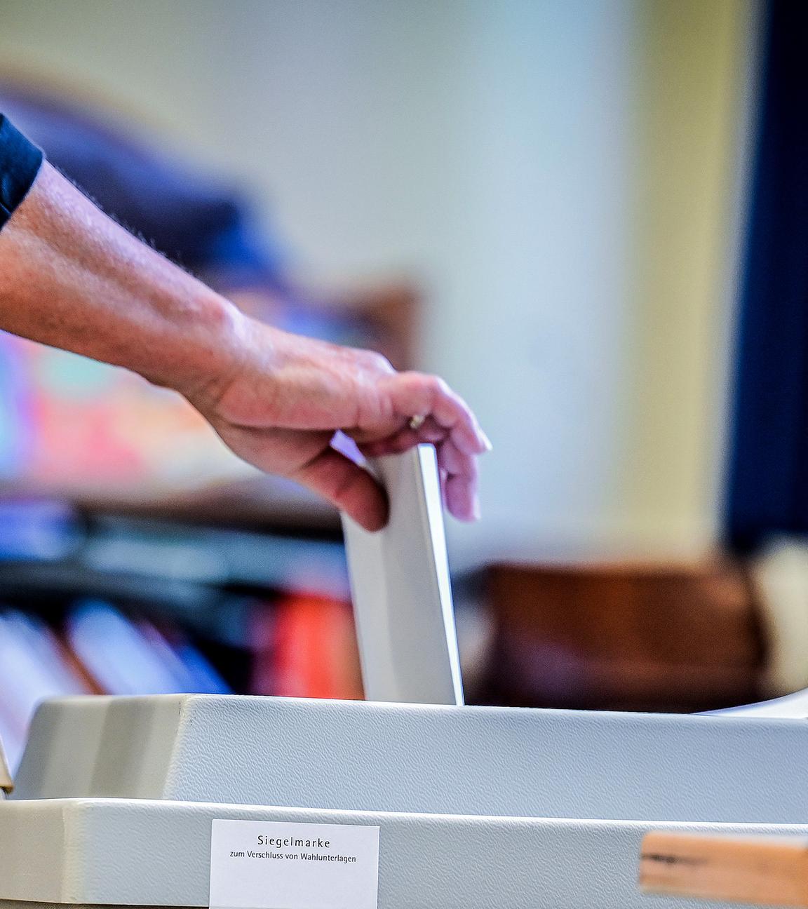 Eine Frau wirft ihren Wahlzettel in die Wahlurne