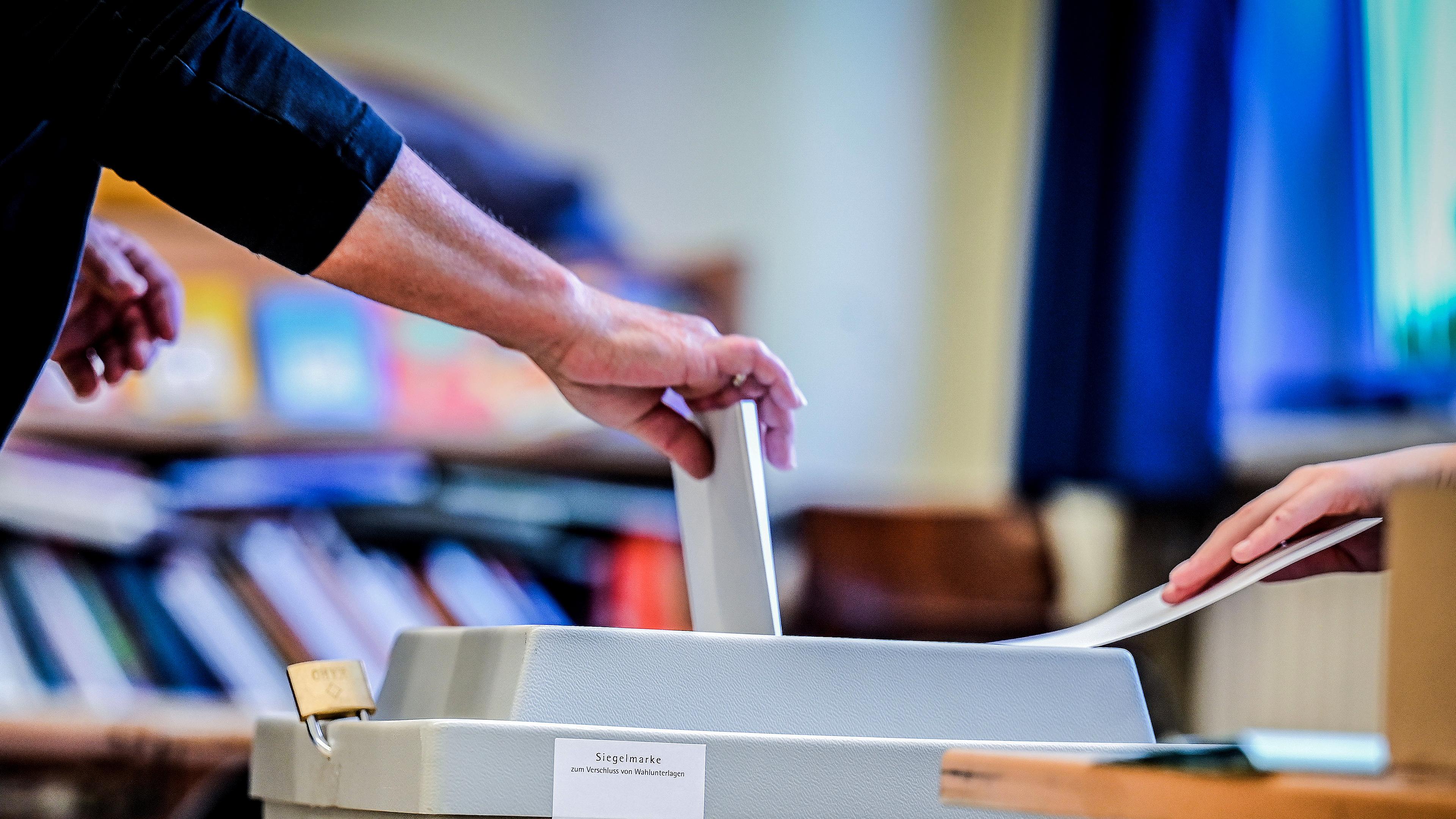 Eine Frau wirft ihren Wahlzettel in die Wahlurne