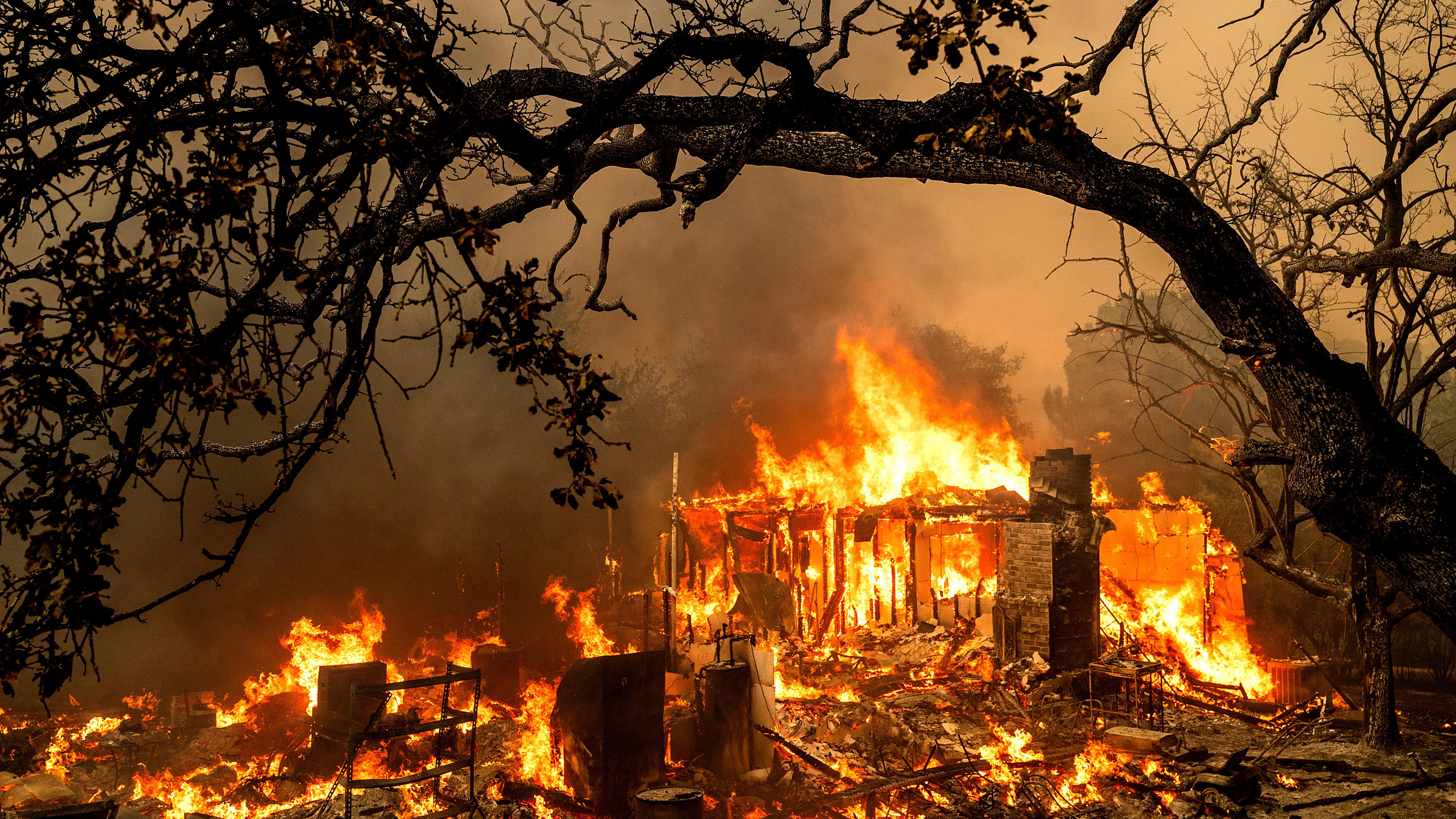 USA, Oroville: Flammen verzehren ein Gebäude in der Bessie Lane, während das Thompson Fire brennt