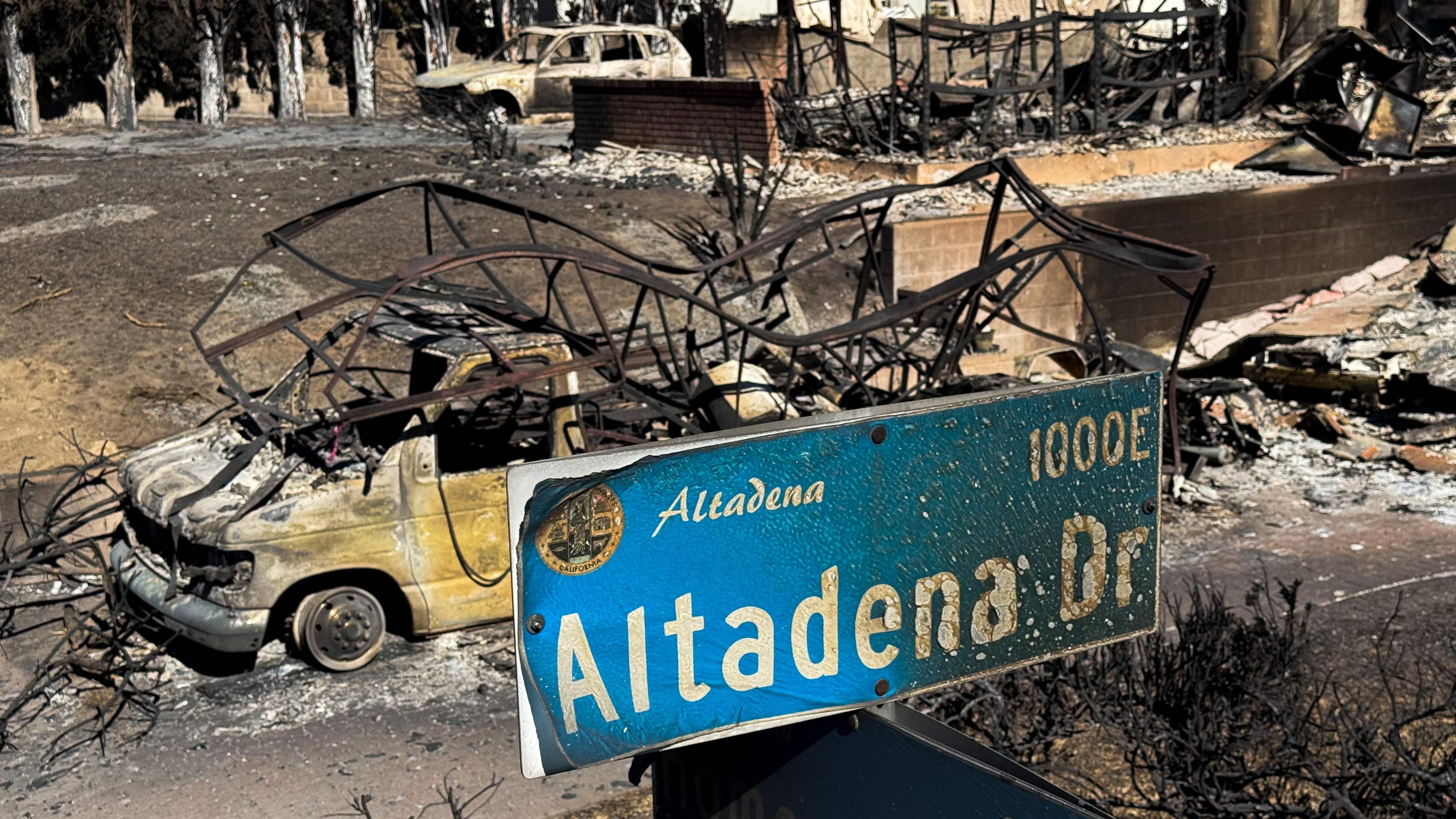 An overhead pole camera image shows wildfire damage to an Altadena Drive street sign and home destroyed by the Eaton Fire in Altadena, Los Angeles County, California on January 14, 2025.