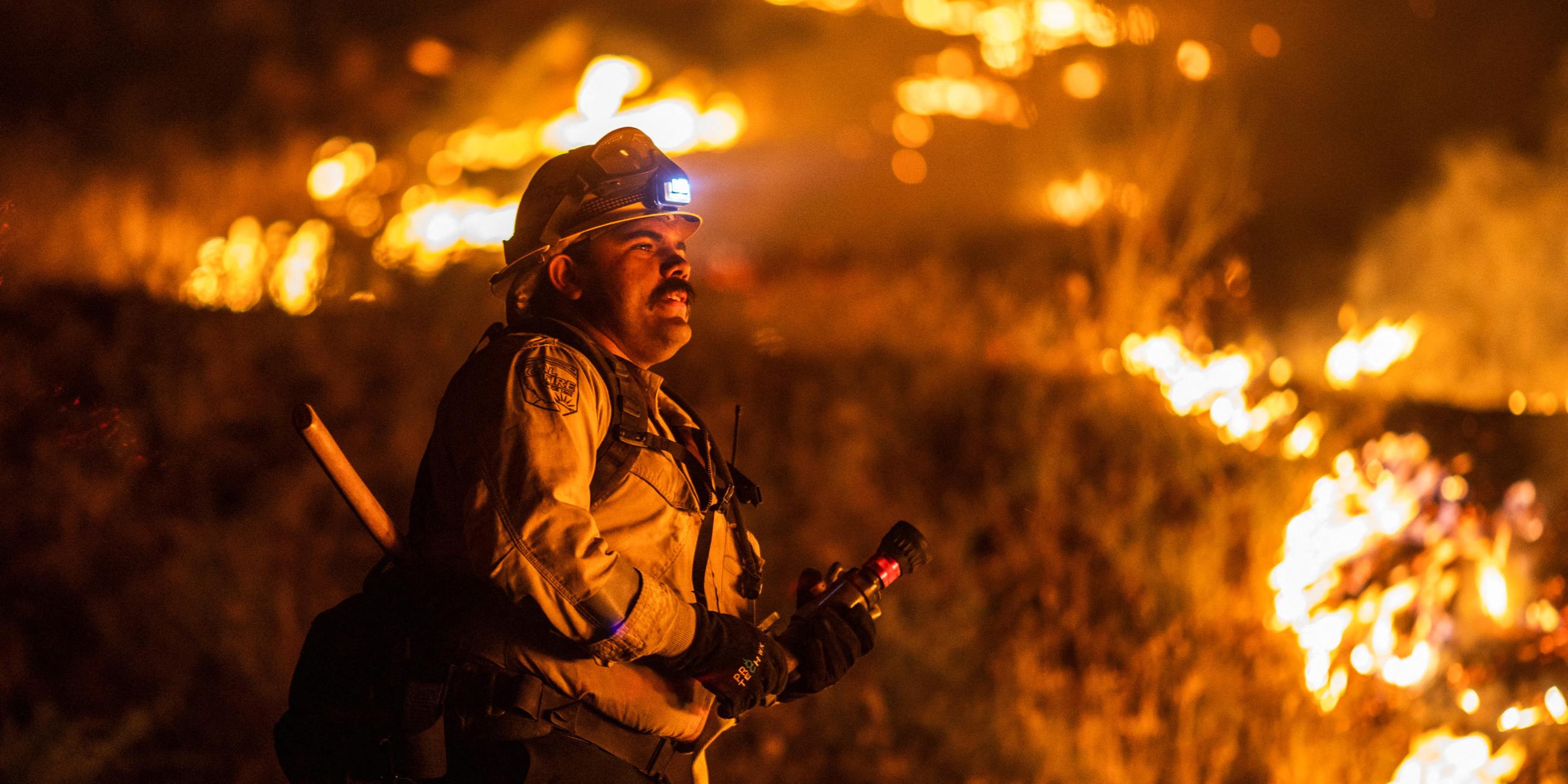 Ein Feuerwehrmann von Cal Fire bekämpft den Brückenbrand, der Berggemeinden nordöstlich von Los Angeles in Wrightwood, Kalifornien