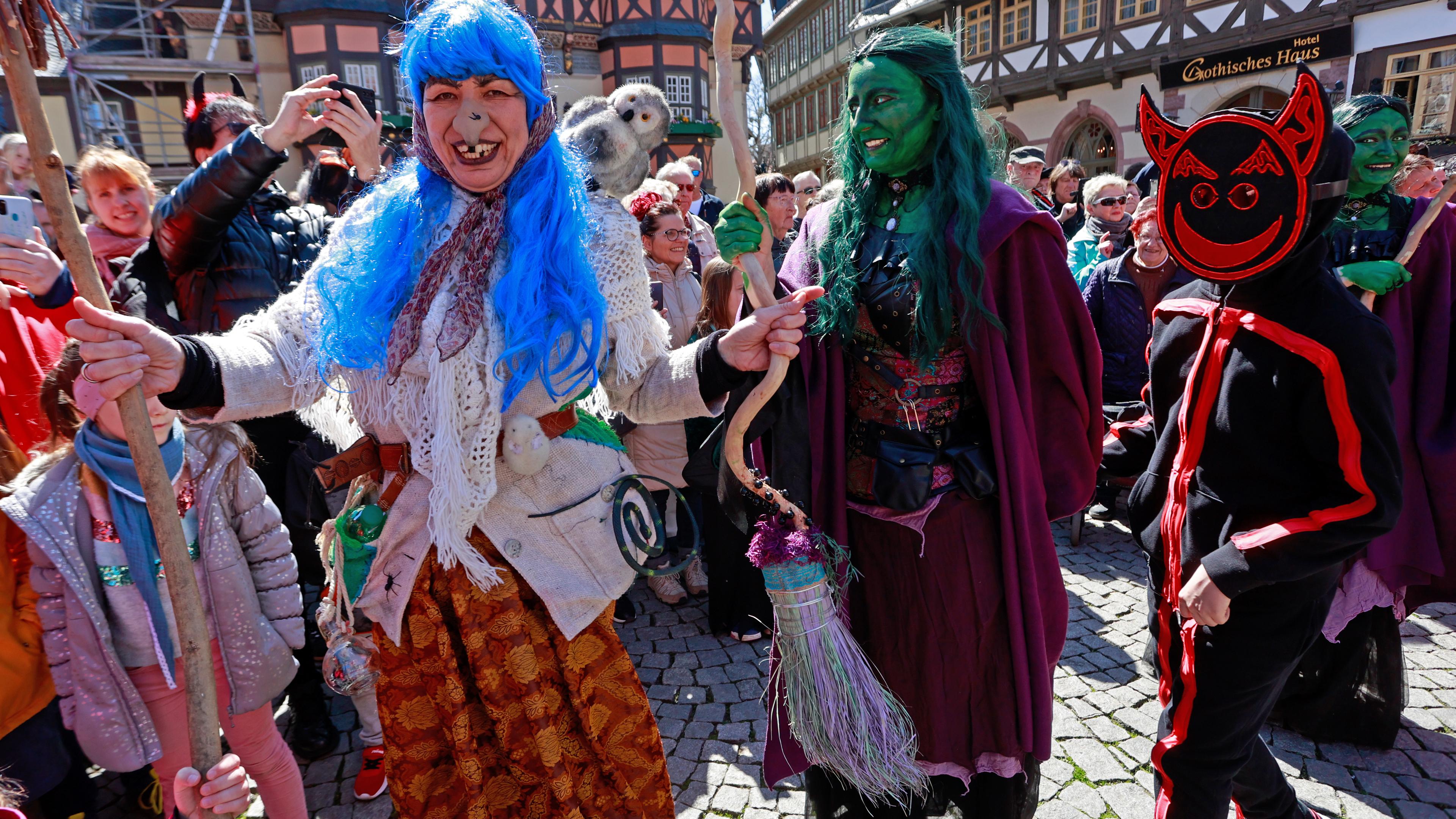  Im Kostüm tanzen als Hexen und Teufel verkleidete Menschen in Wernigerode vor dem Rathaus auf dem Marktplatz.