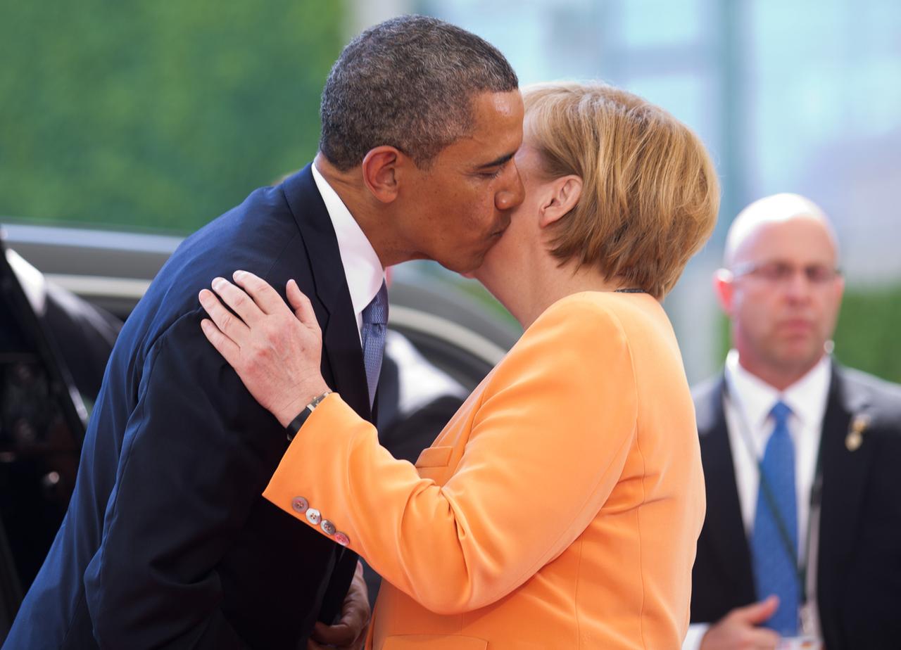Barack Obama und Angela Merkel küssen sich auf die Wange.