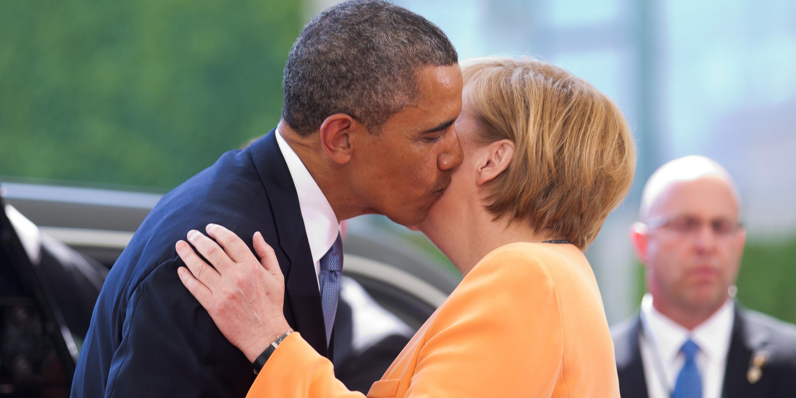 Barack Obama und Angela Merkel küssen sich auf die Wange.