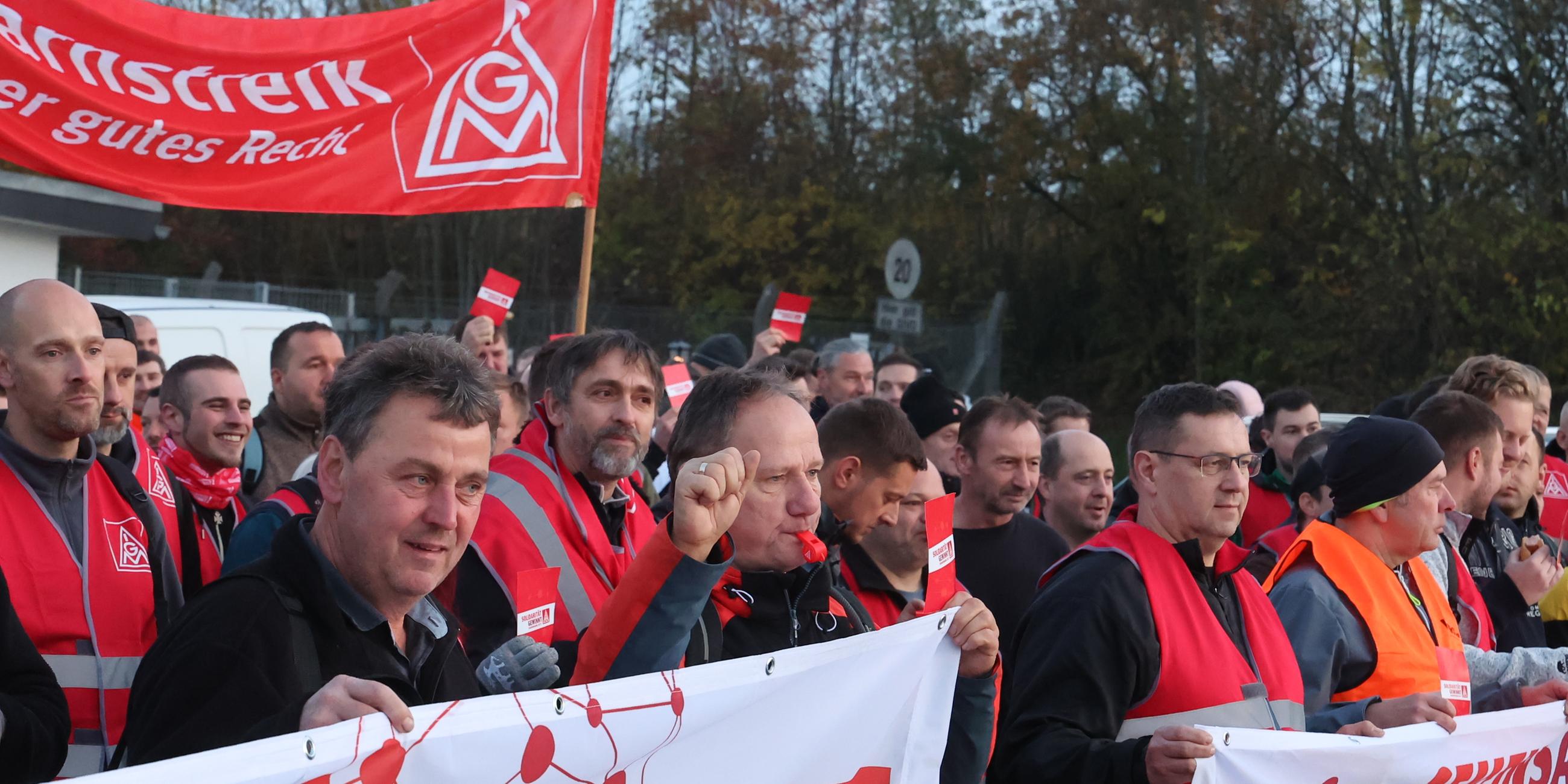 Thüringen, Gera: Arbeiter stehen bei einem Warnstreik der IG Metall am Eingang des Kaeser Werkes