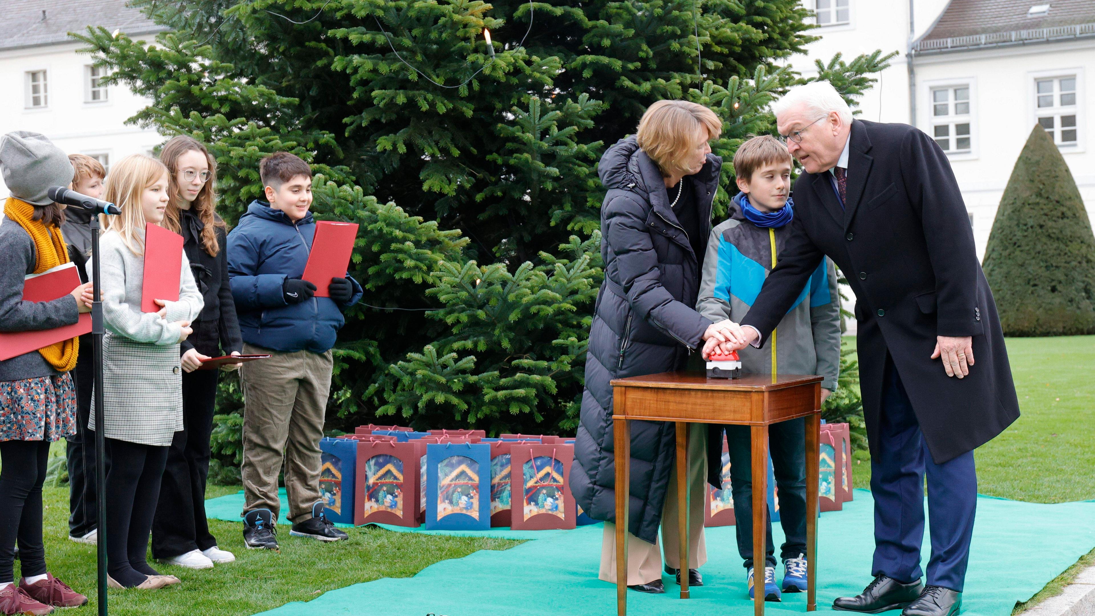 Bundespräsident Steinmeier und seine Frau entzünden die Lichter am Weihnachtsbaum vor dem Schloss Bellevue.