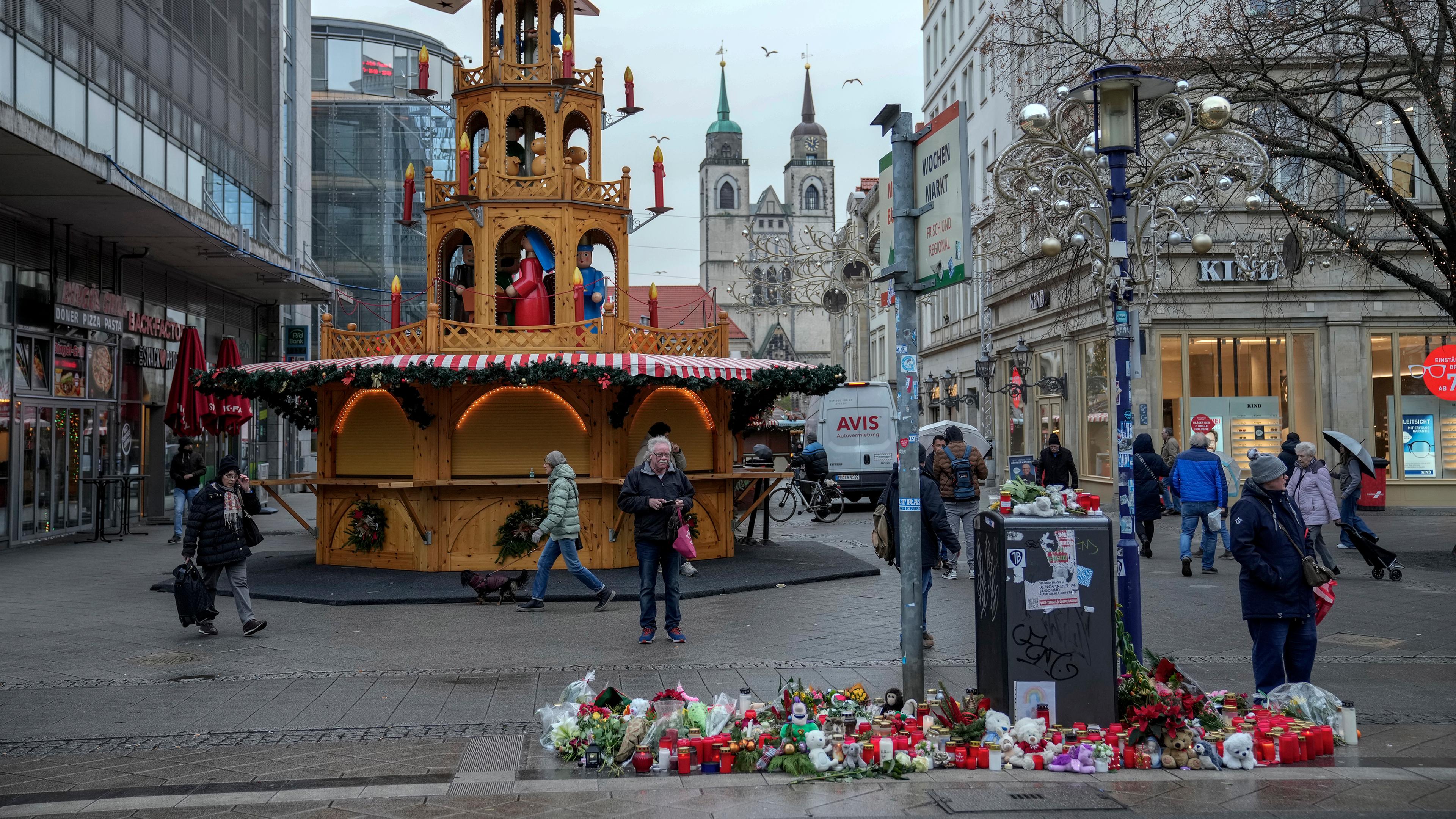 Menschen gehen auf dem Weihnachtsmarkt in Magdeburg spazieren, wo am Freitagabend ein Auto in eine Menschenmenge fuhr