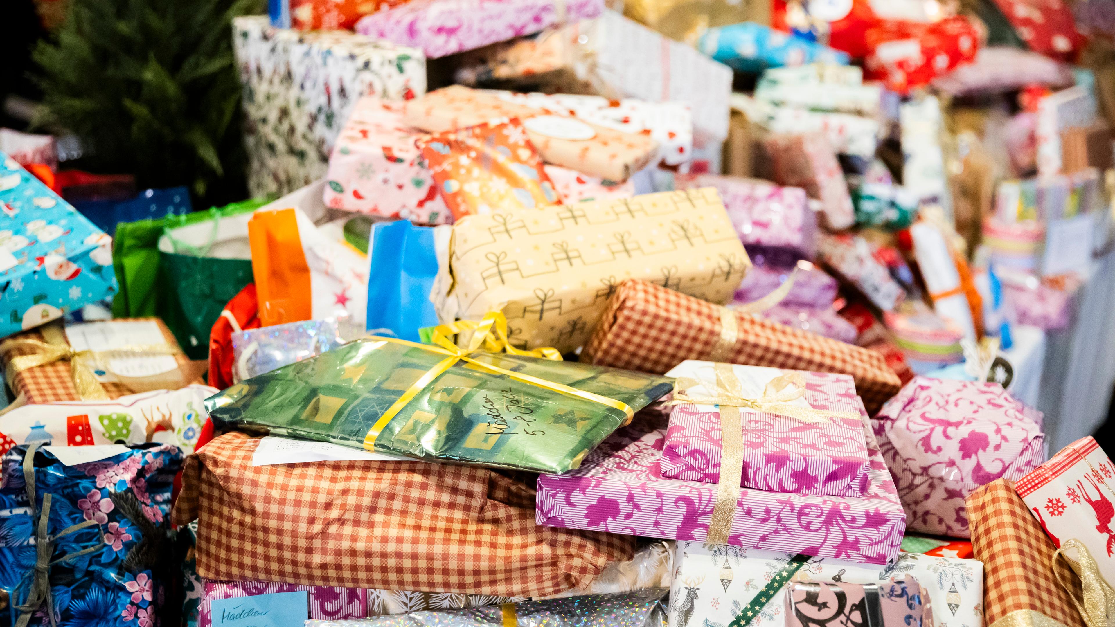 Auf einem Tisch liegen viele Weihnachtsgeschenke.