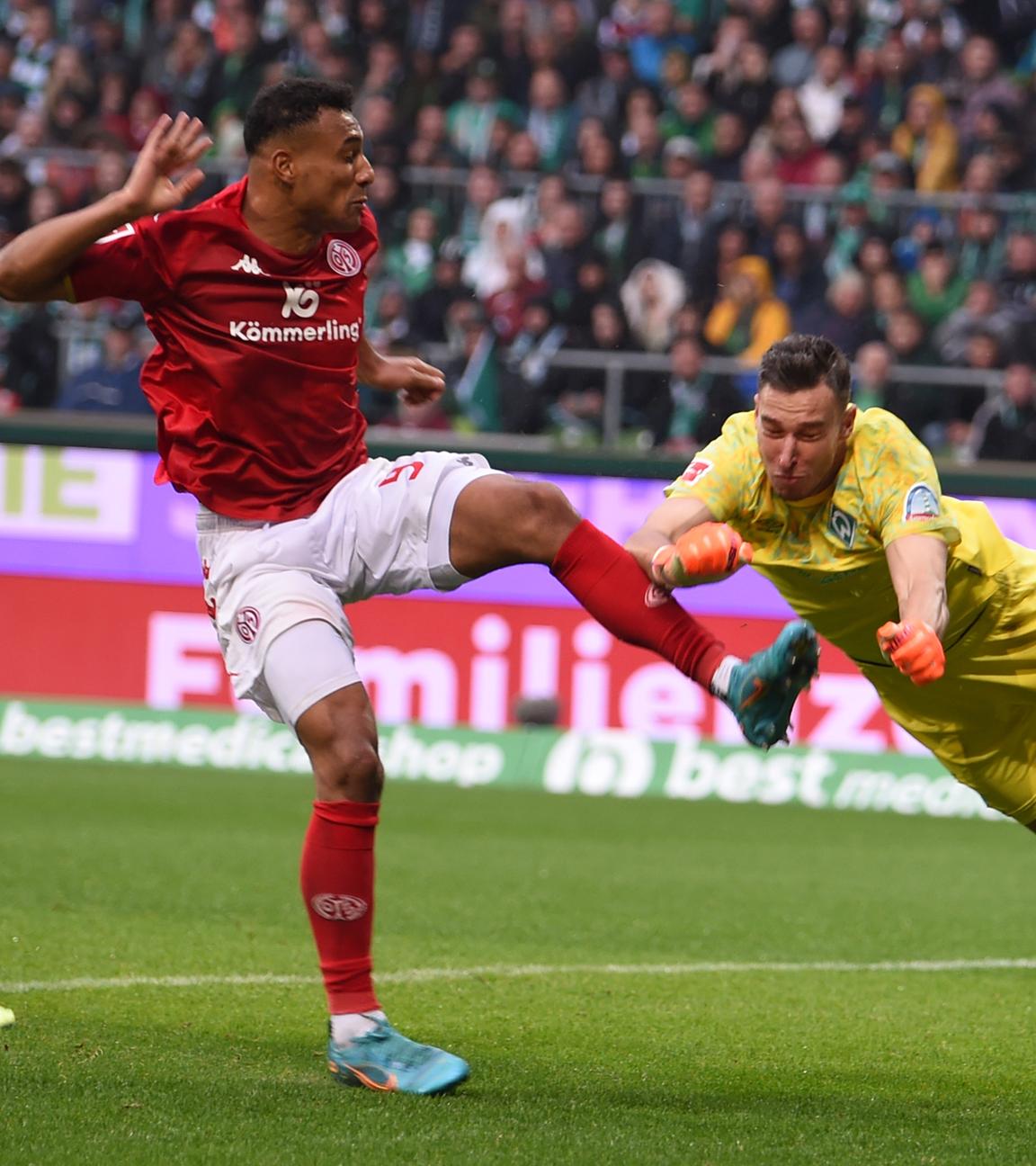 15.10.2022, Bremen: Fußball: Bundesliga, Werder Bremen - FSV Mainz 05, 10. Spieltag, wohninvest Weserstadion. Werders Torwart Jiri Pavlenka (r) klärt vor dem Mainzer Karim Onisiwo.