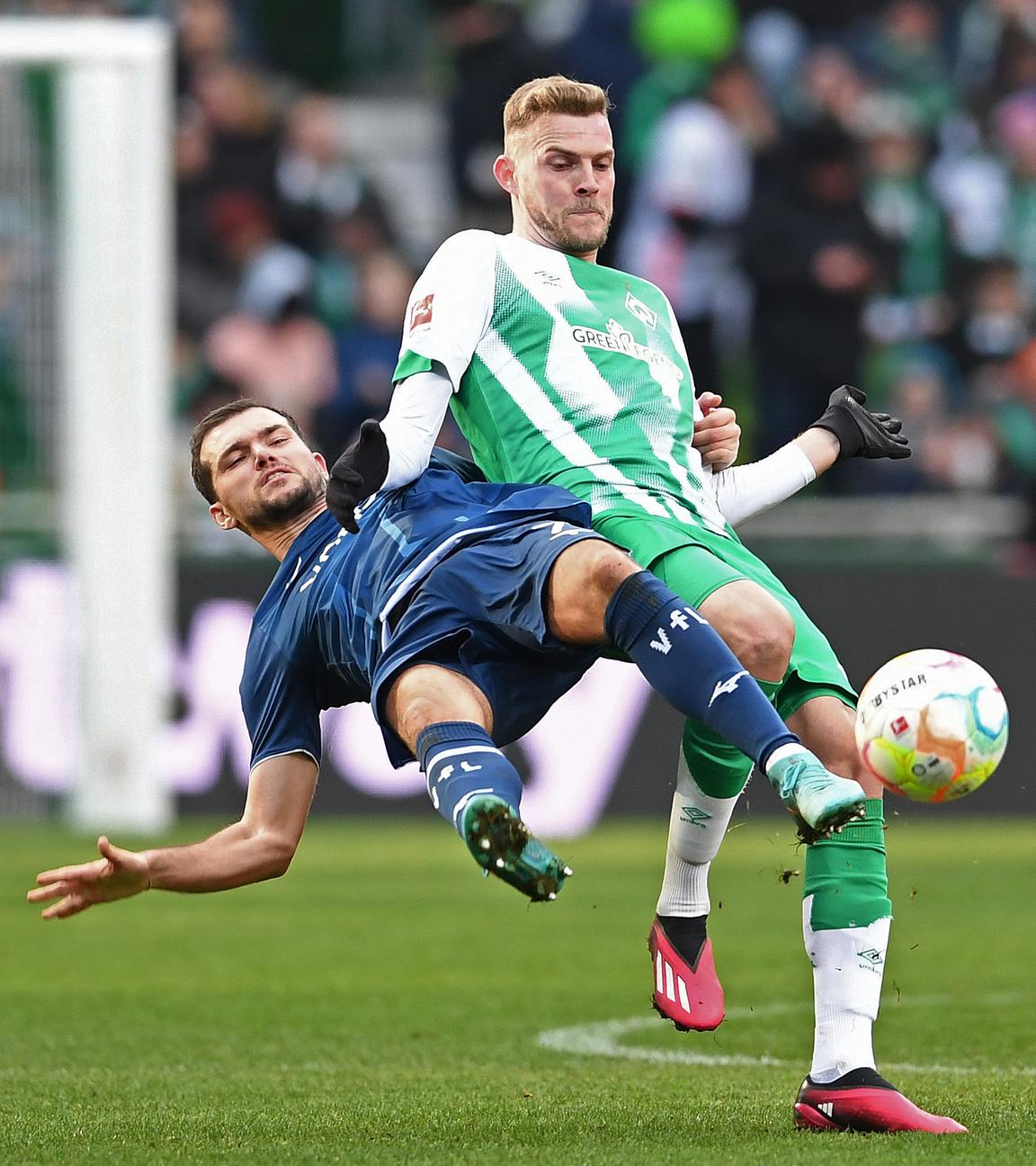 25.02.2023, Bremen: Fußball: Bundesliga, Werder Bremen - VfL Bochum, 22. Spieltag, wohninvest Weserstadion. Bremens Marvin Ducksch (r) kämpft gegen Bochums Kevin Stöger um den Ball.