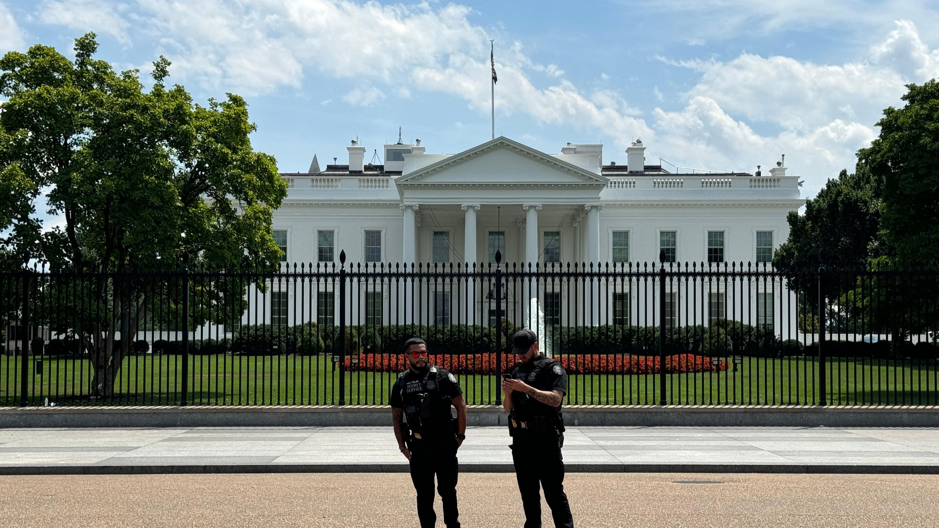 Zwei Beamte des Secret Service stehen vor dem Weißen Haus.