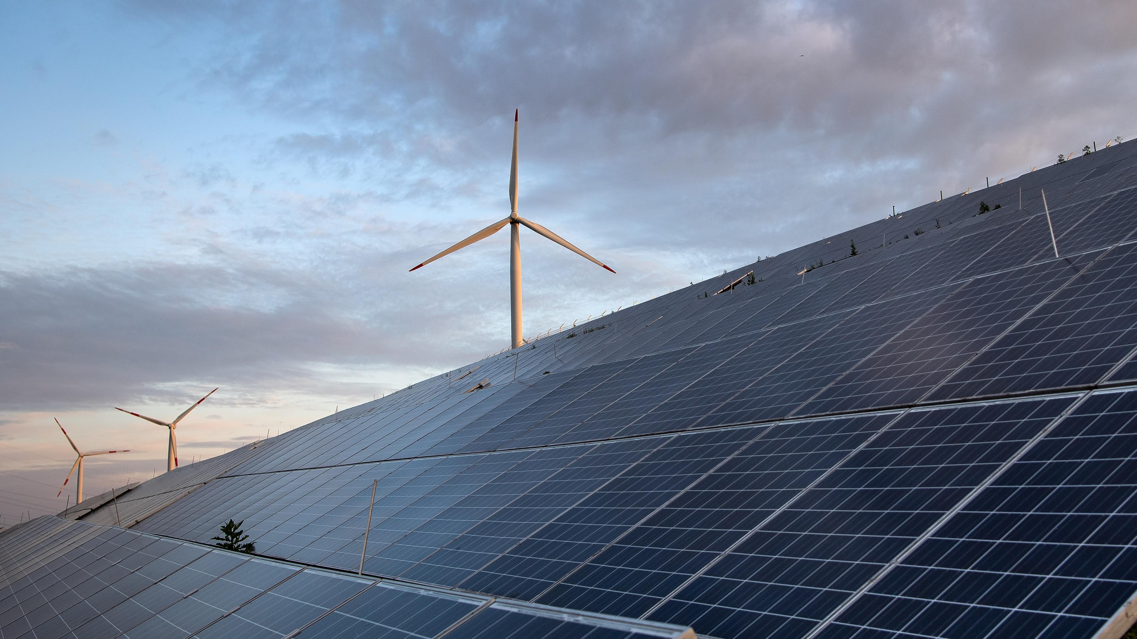 Windkraftanlagen stehen hinter Photovoltaikanlagen auf der Blocklanddeponie in Bremen.