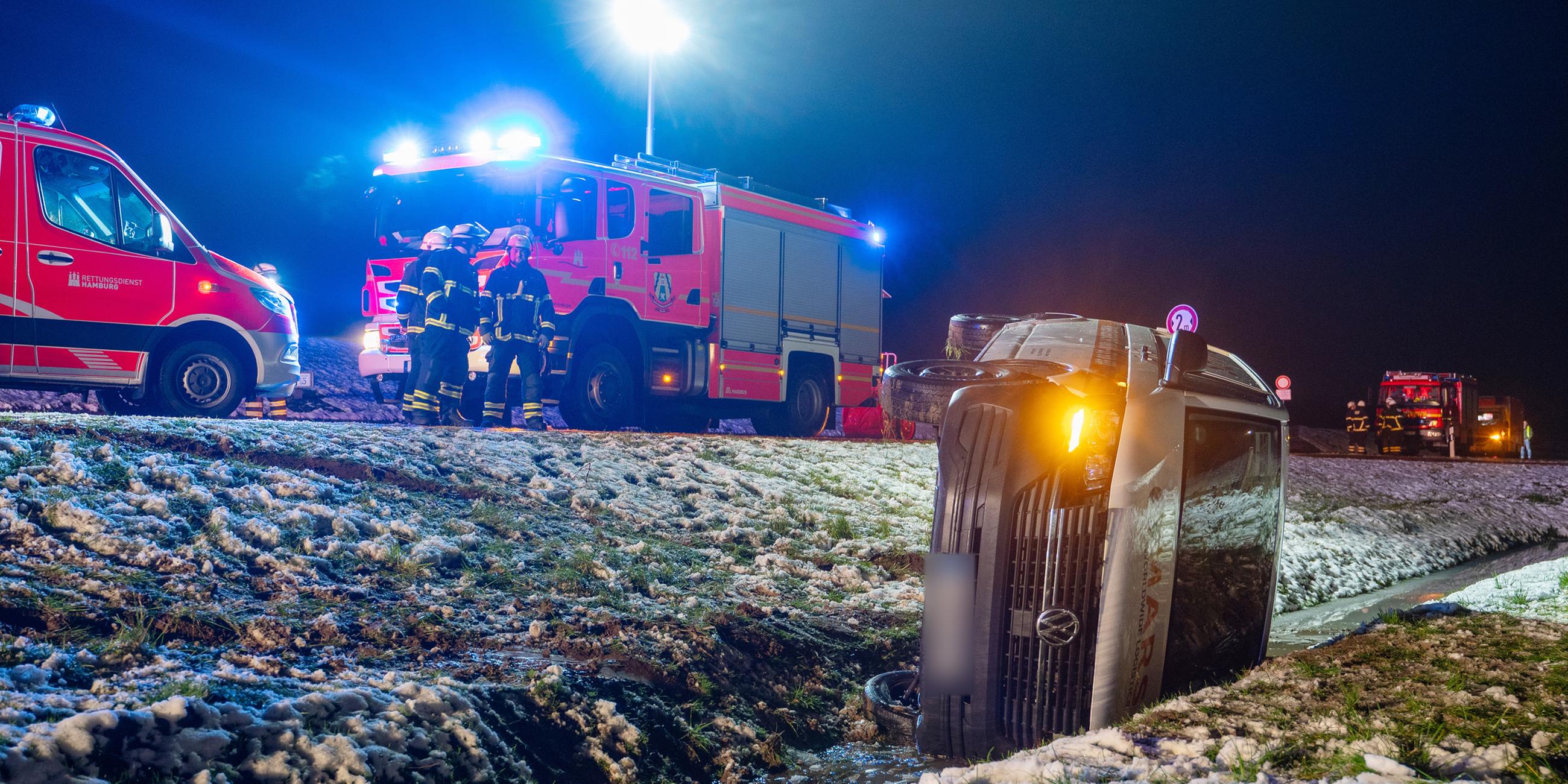 Ein Auto liegt nach einem Unfall nach Einbruch der Dunkelheit in einem Graben. 