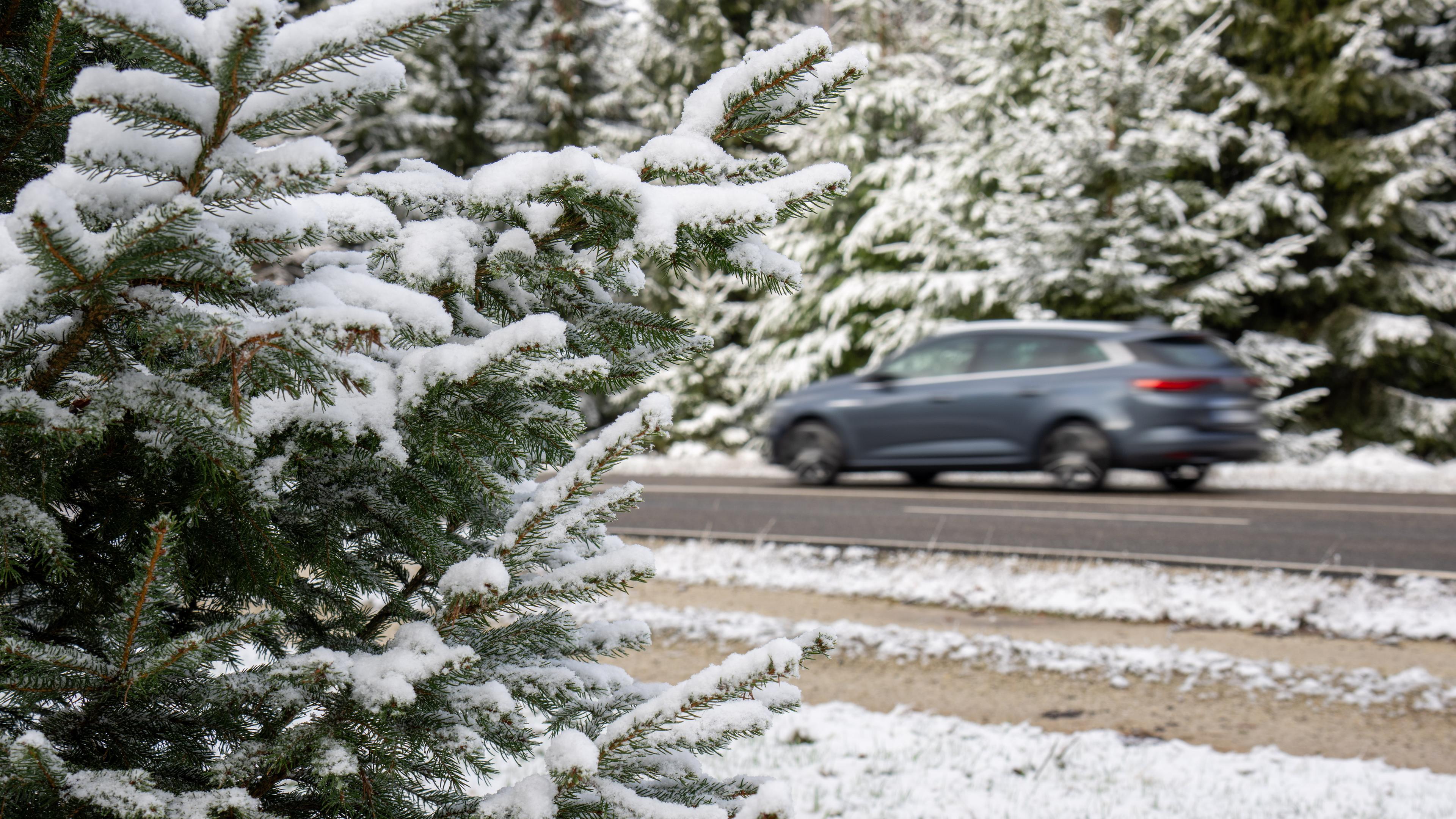 Ein Auto fährt auf der L 164 durch die Schneelandschaft rund um den Erbeskopf im Hunsrück.