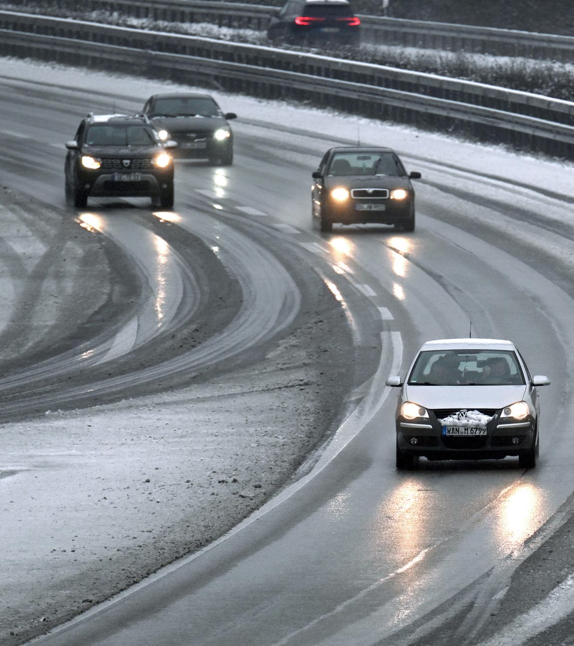 Nordrhein-Westfalen, Gelsenkirchen: Autos fahren auf der Autobahn 52 durch den Schneematsch. 