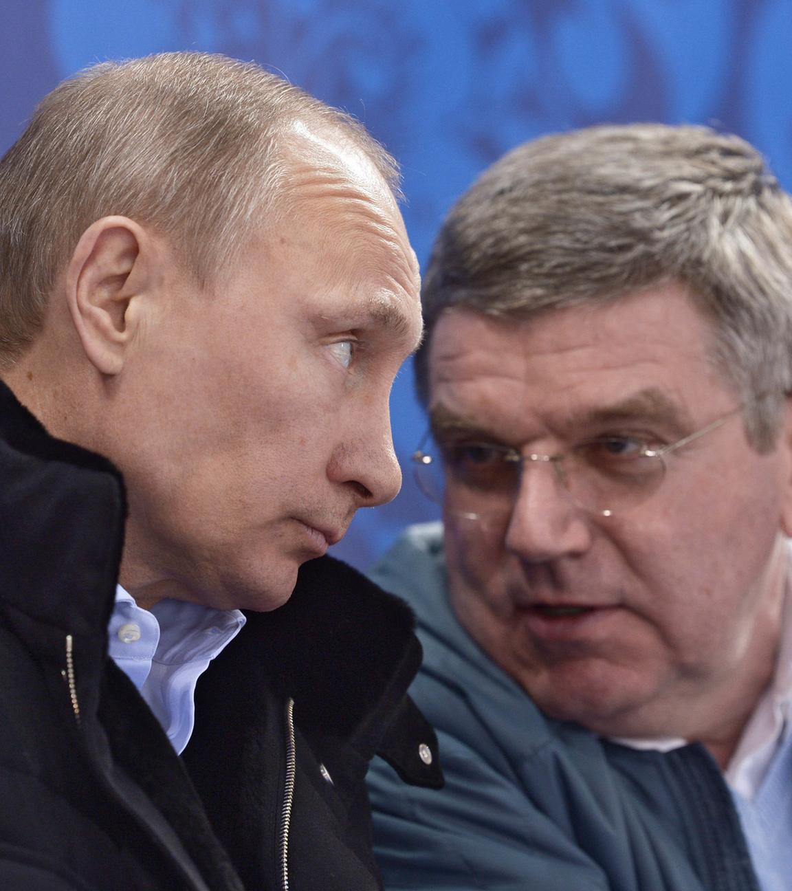 Russlands Präsident Wladimir Putin spricht mit IOC-Präsident Thomas Bach.