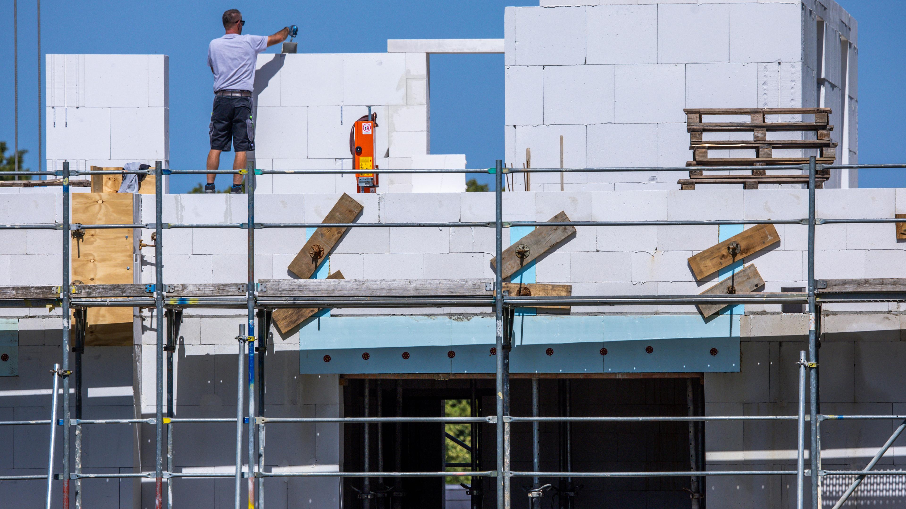 Wohnungsbau: Ein Bauarbeiter arbeitet am Neubau eines Mehrfamilienhauses.