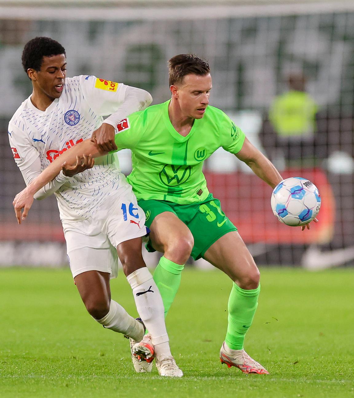 Andu Kelati von Holstein Kiel und Yannick Gerhardt vom VfL Wolfsburg kämpfen um den Ball