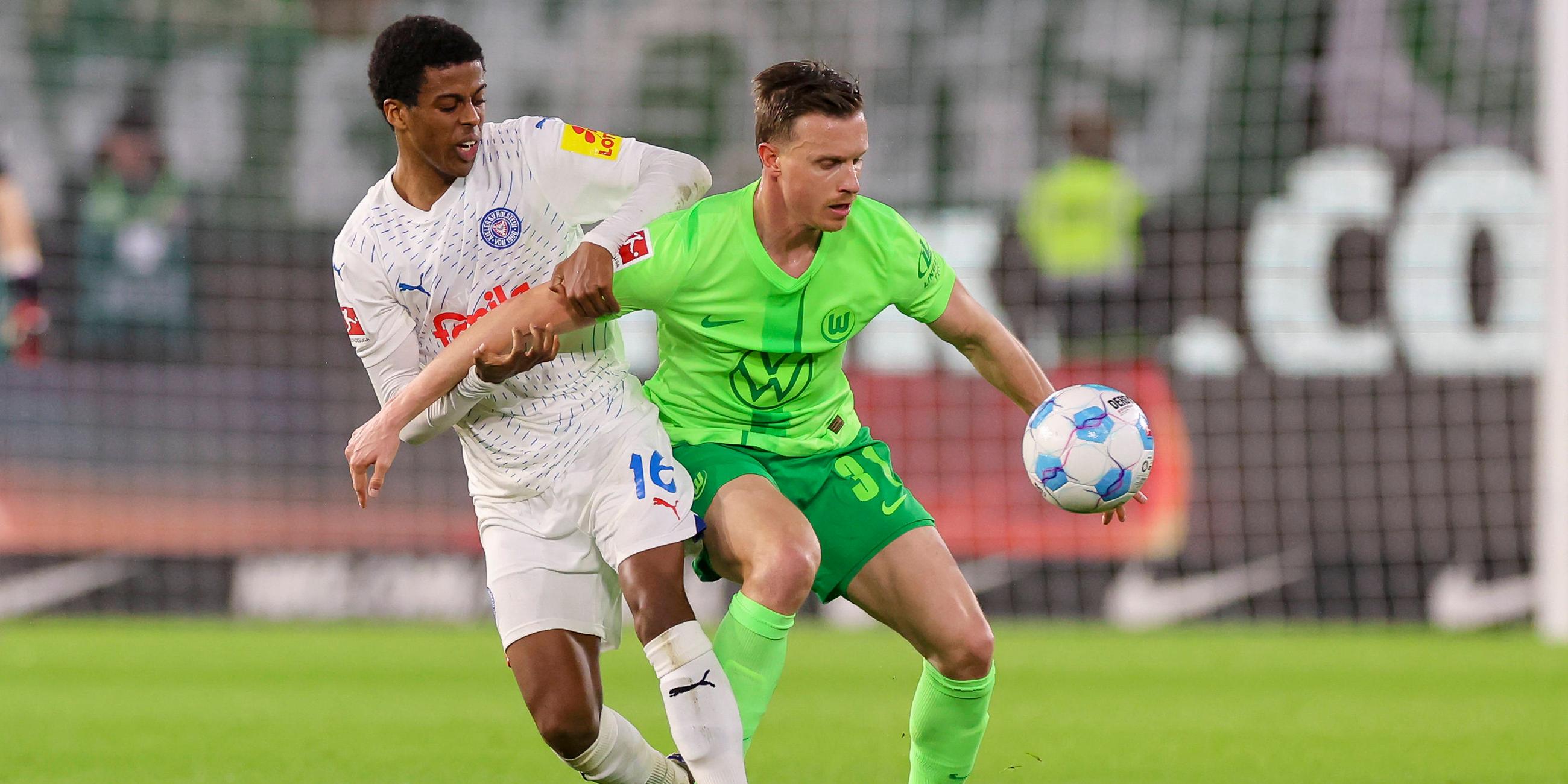 Andu Kelati von Holstein Kiel und Yannick Gerhardt vom VfL Wolfsburg kämpfen um den Ball