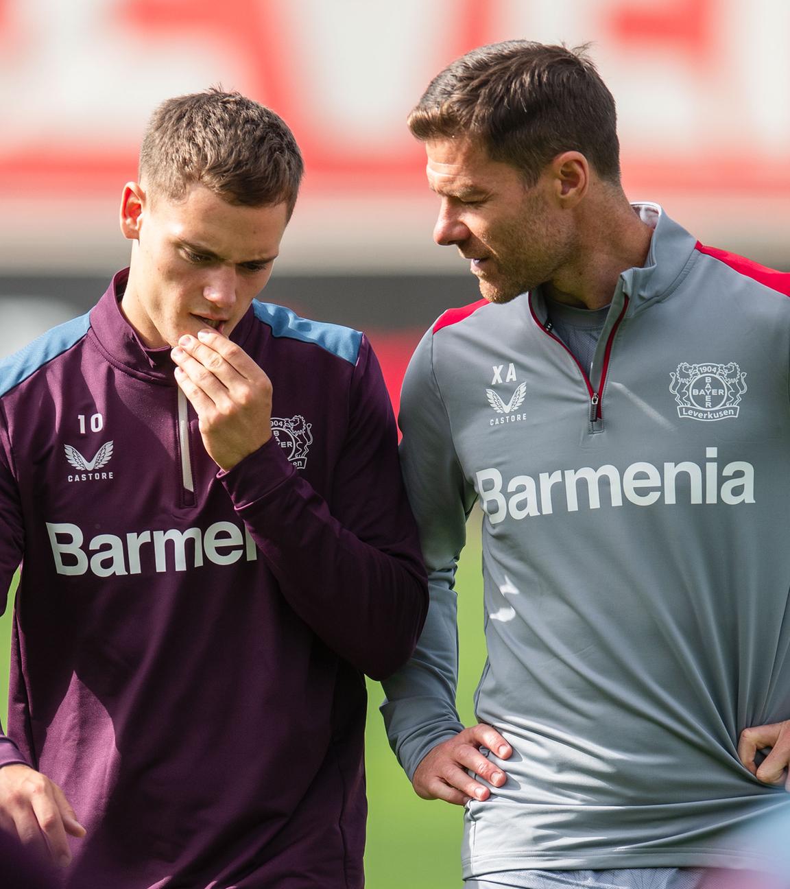 Xabi Alonso (r) unterhält sich beim Abschlusstraining mit Florian Wirtz.