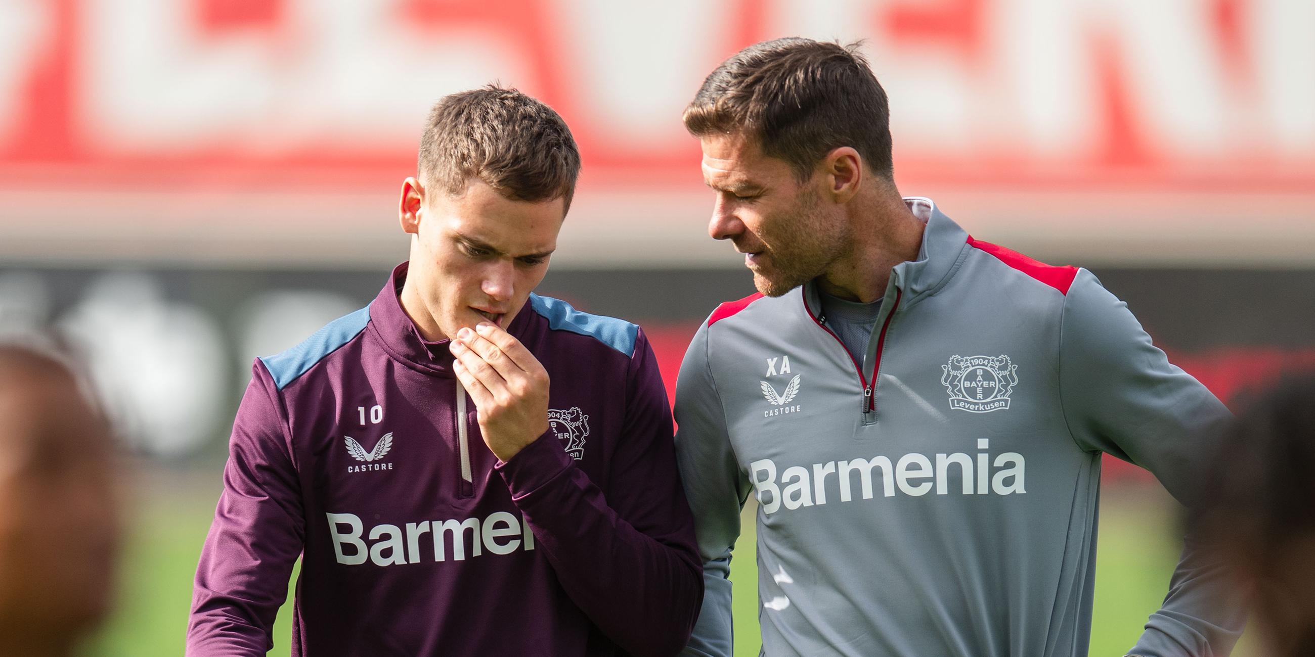 Xabi Alonso (r) unterhält sich beim Abschlusstraining mit Florian Wirtz.