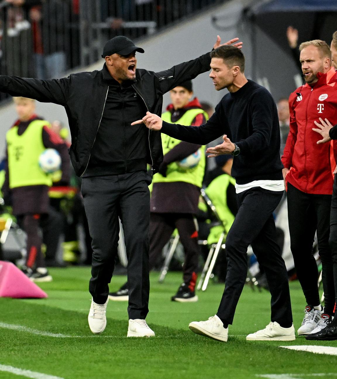 Leverkusens Trainer Xabi Alonso (2vl) und Münchens Trainer Vincent Kompany (l) gestikulieren am Spielfeldrand. 