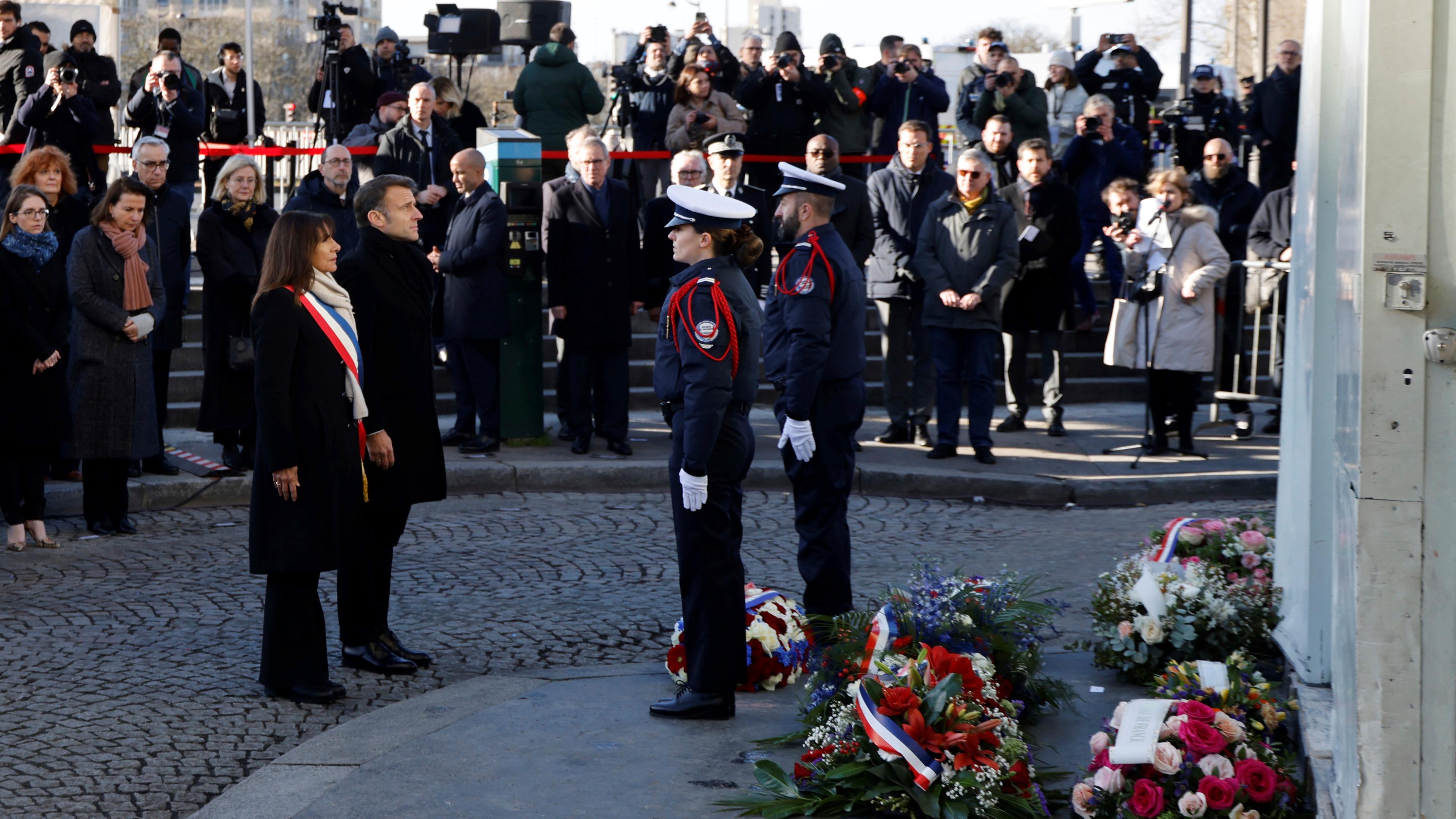 Frankreich, Paris: Der französische Präsident Emmanuel Macron und die Bürgermeisterin von Paris Anne Hidalgo während der Gedenkfeier zum 10. Jahrestag des Anschlags auf "Charlie Hebdo