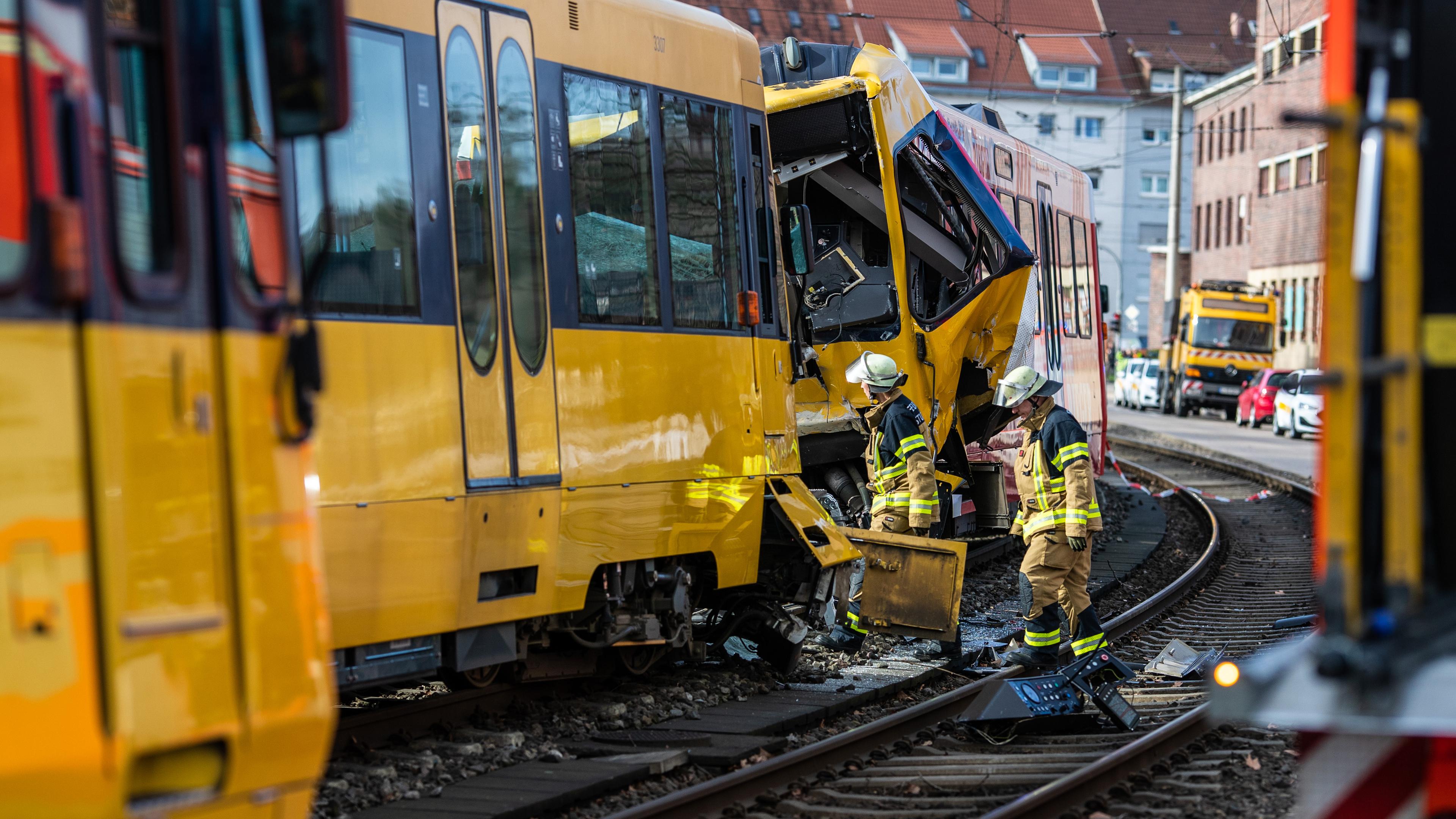 Einsatzkräfte der Feuerwehr arbeiten an zwei zerstörten Stadtbahnen am 23.02.2024 in Stuttgart.