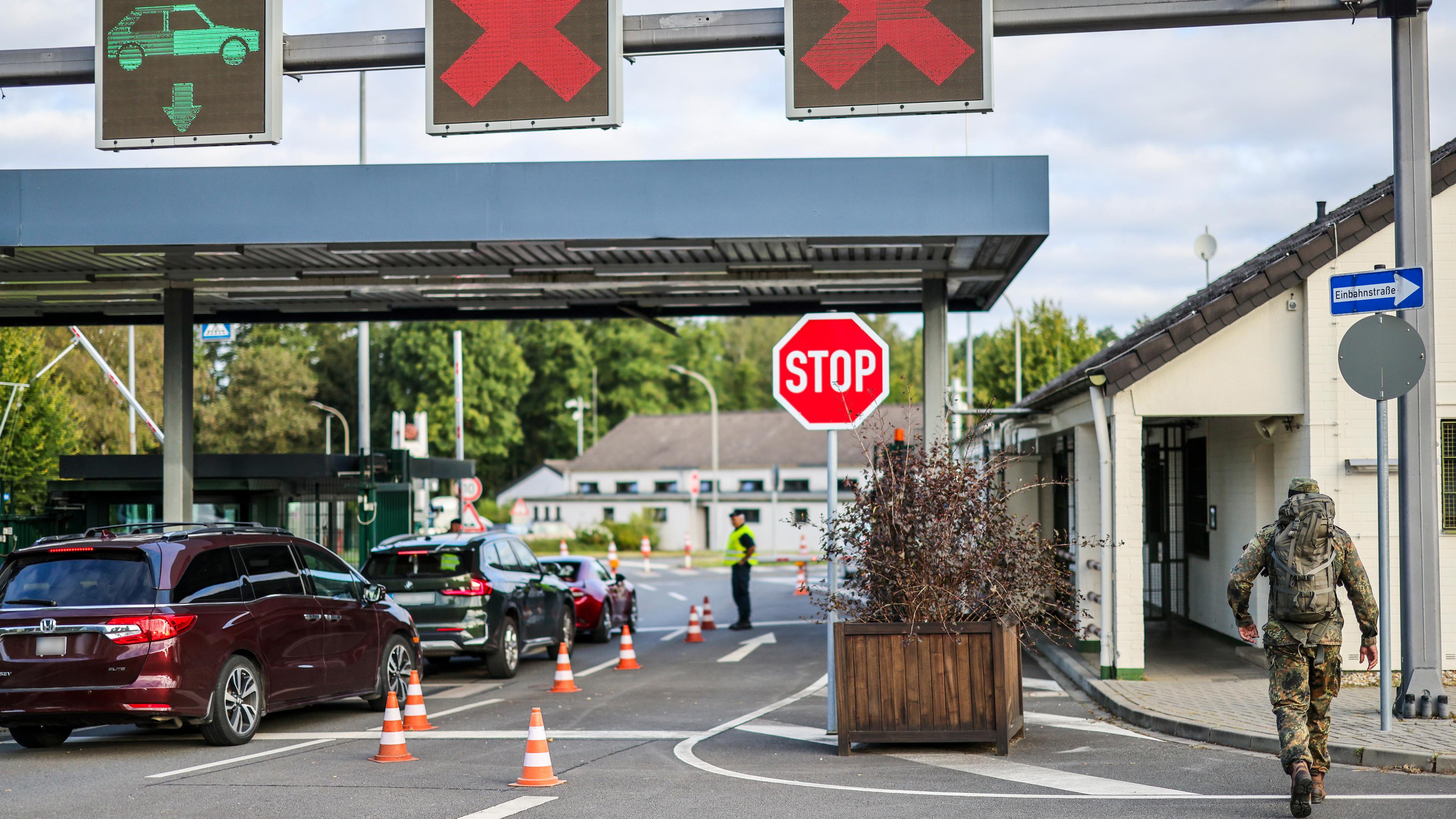 Am Morgen kontrollieren Soldaten die Einfahrt in die Nato Air Base, ein Soldat in Tarnkleidung ist zu Fuß in Richtung der Air Base unterwegs. 